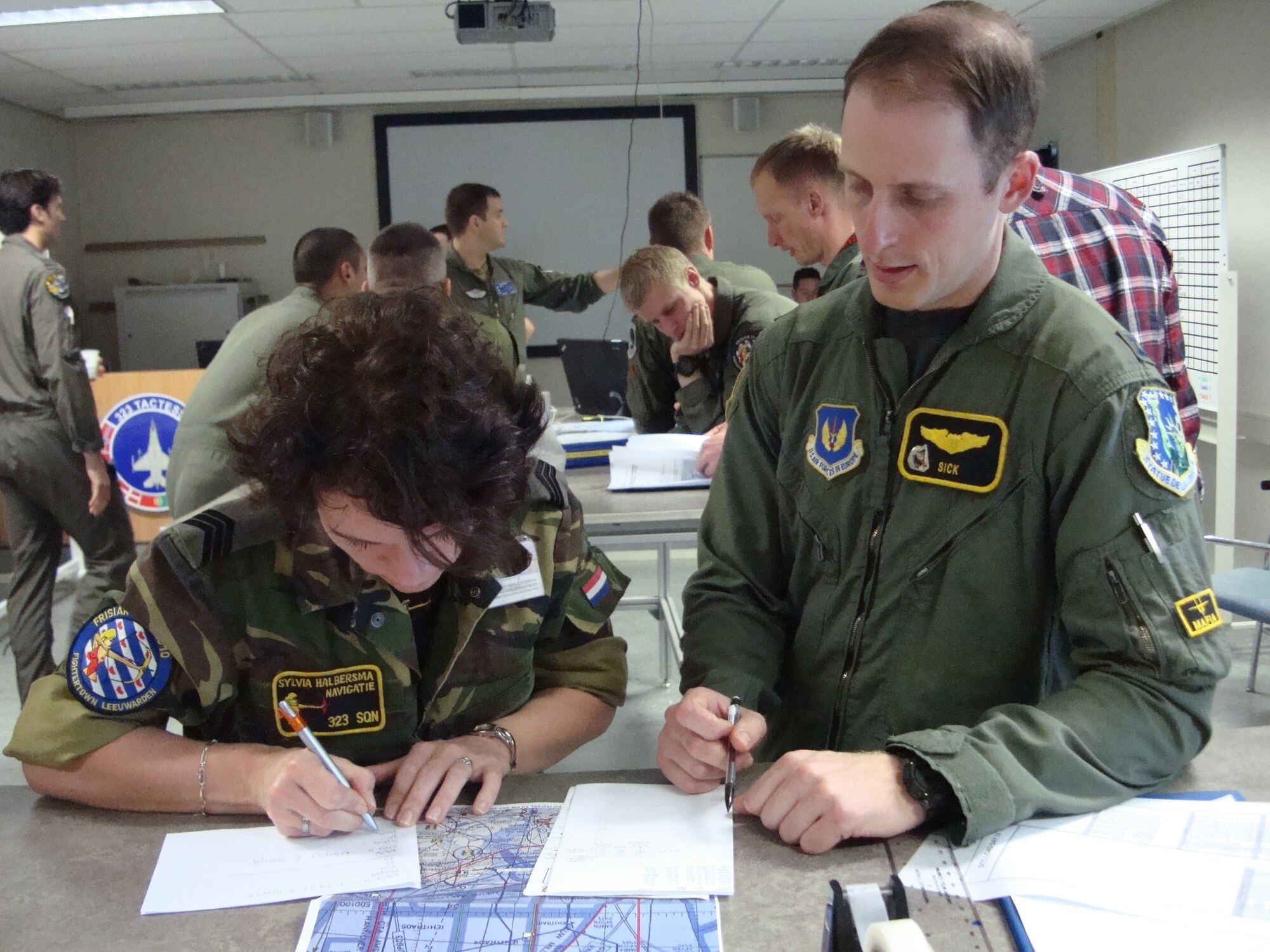 Capt. John Friedman, 493rd Fighter Squadron, discusses where he will be flying during mission planning with a Dutch intelligence officer April 15 during FRISIAN FLAG 2010 at Leeuwarden Air Base, the Netherlands.  With participants from seven different countries, the multi-nation exercise will last until April 22 and is meant to train pilots on offensive and defensive roles through realistic scenarios. (U.S. Air Force photo/1st Lt. Haley Ageton)