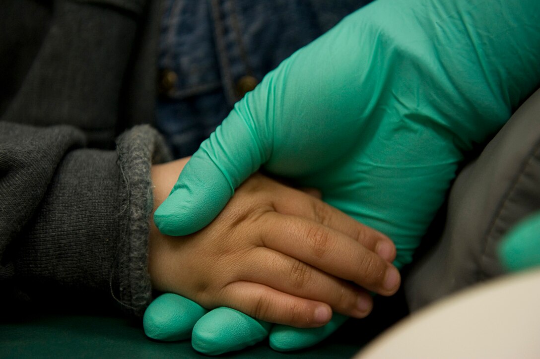 A dental assistant holds 3-year-old, Tiana Griest's hand during a dental procedure April 15, 2010, in Kotzebue, Alaska. Airmen deployed in support of Operation Arctic Care, a joint innovative readiness training exercise aimed at providing medical care to remote villages in northeast Alaska. (U.S. Air Force/Senior Airman Christopher Griffin)


