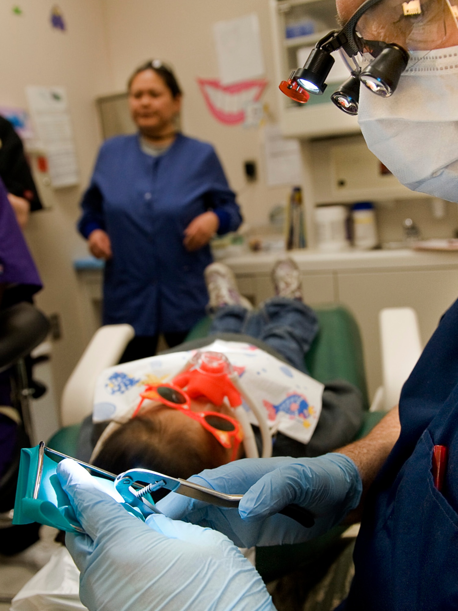 Maj. Blake Moore prepares Tiana Griest, 3, for a tooth extraction April 15, 2010, in Kotzebue, Alaska. Major Moore is deployed to Kotzebue as part of Operation Arctic Care, a joint innovative readiness training exercise. Major Moore is a dentist deployed from Elmendorf Air Force Base, Alaska. (U.S. Air Force/Senior Airman Christopher Griffin)