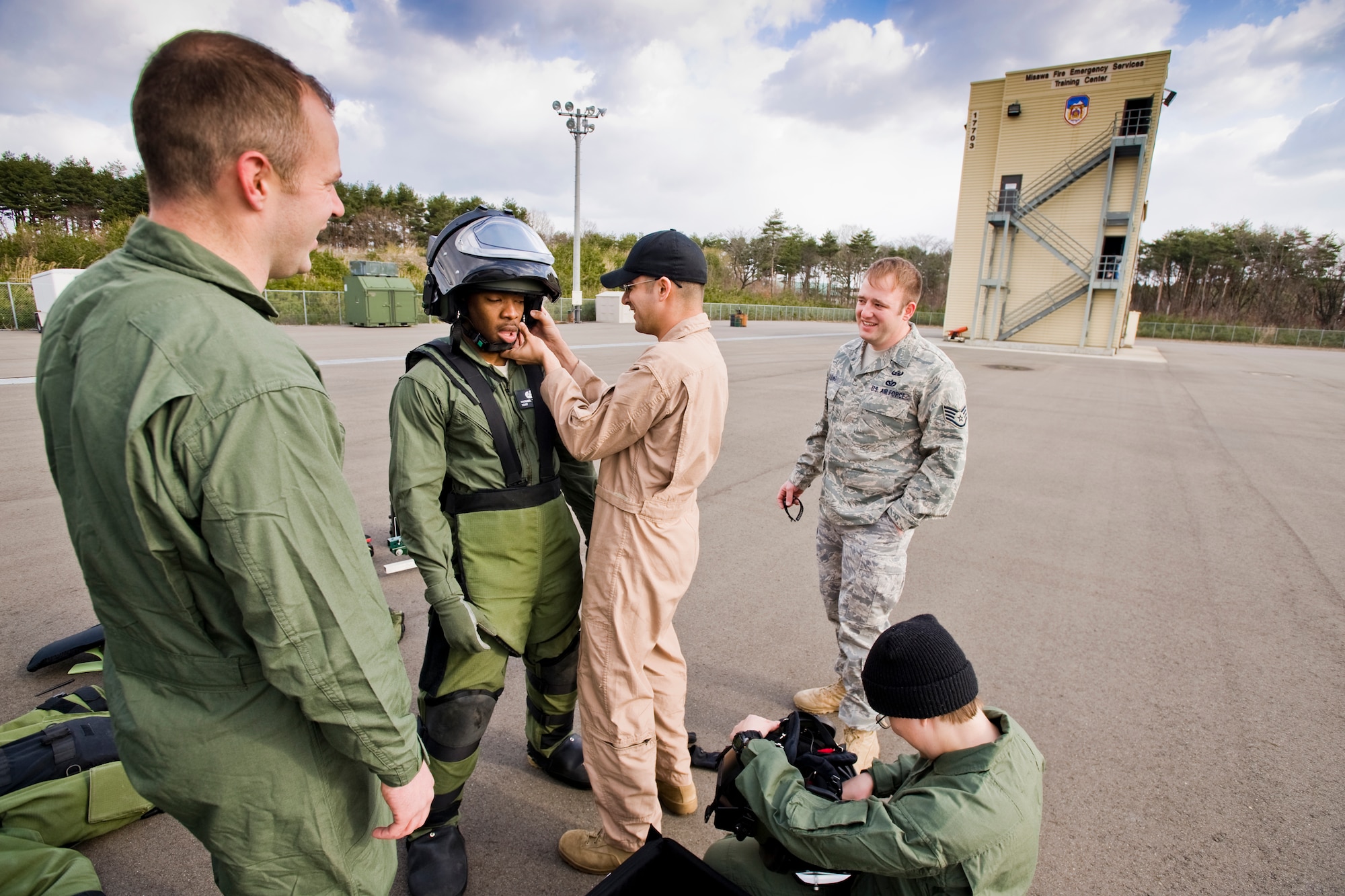 MISAWA AIR BASE, Japan -- Members of the 35th Civil Engineer Squadron explosive ordnance disposal flight share laughs before beginning bomb-suit stress drills April 15 at the Misawa Fire Emergency Services Training Center. The drills prepare EOD members for the physical tasks involved with handling explosive devices. (U.S. Air Force photo/Senior Airman Jamal D. Sutter)