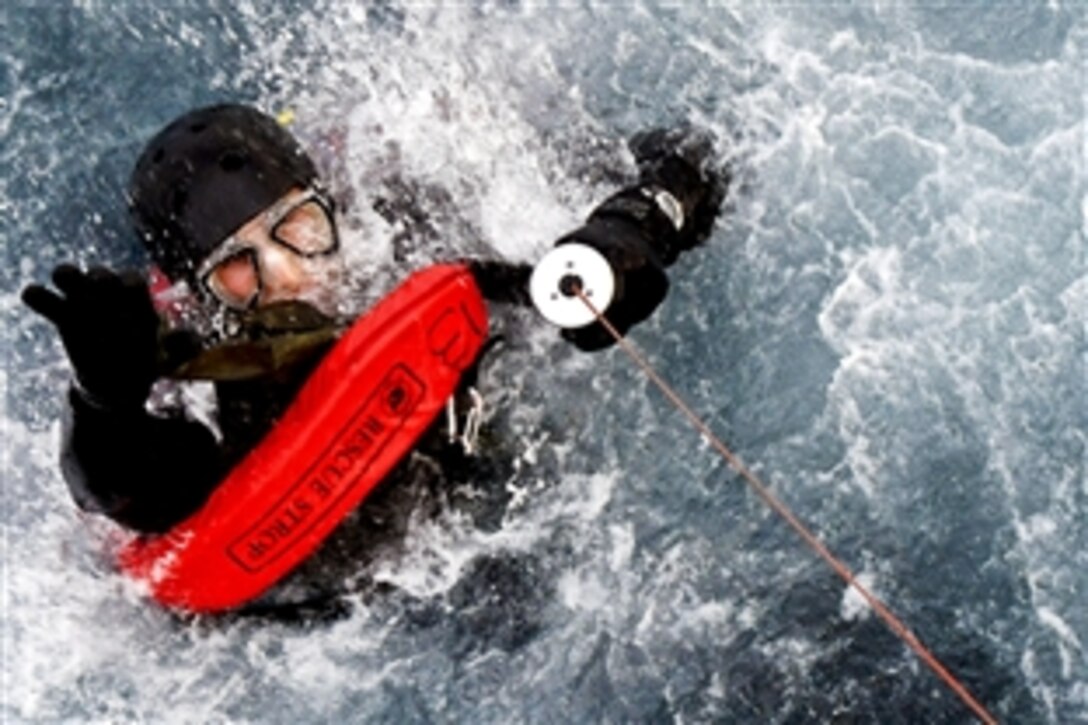 U.S. Navy Lt. Michael Hodges pulls himself up through a mechanical rescue hoist as he is raised into an SH-60F Sea Hawk helicopter while conducting drills in the Arabian Gulf, April 13, 2010. Hodges is assigned to Explosive Ordnance Disposal Mobile Unit 1.