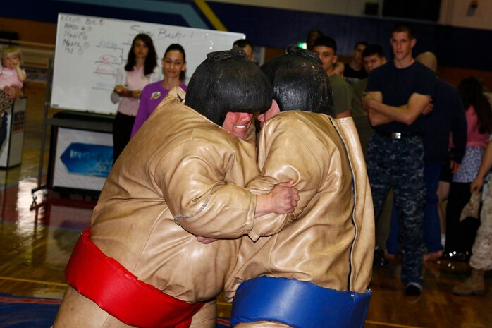 Joshua Blackburn with the Robert M. Casey Medical and Dental Clinic (left) takes on Tracy Mood from Combat Logistics Company 36 during the fourth event of the Commander’s Cup Competition called Sumo Basho at the IronWorks Gym April 16. Competitors suited up in sumo suits and wrestled it out to force their opponents to the ground or out of the designated area.