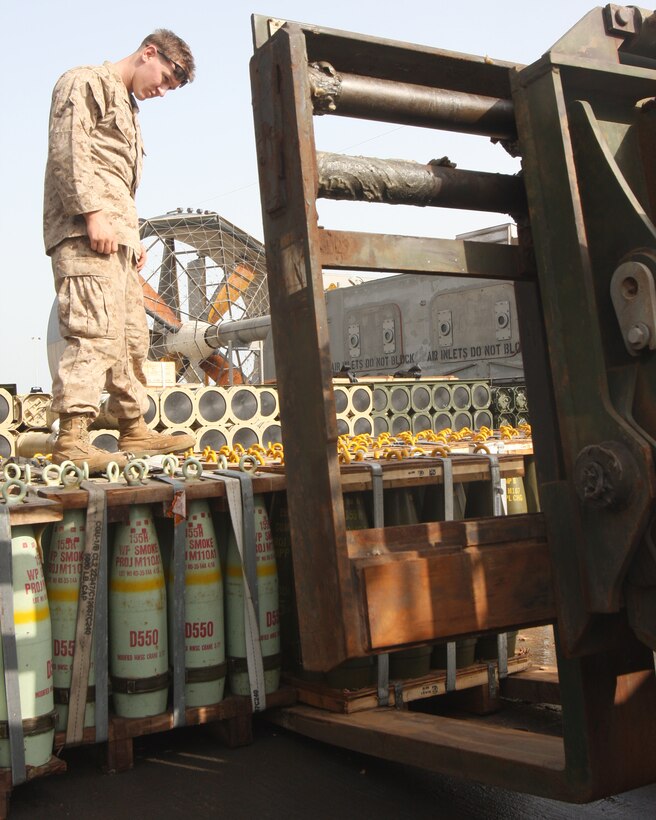 Cpl. Will D. Hoover, ammunition technician with Headquarters platoon, Combat Logistics Battalion 24, 24th Marine Expeditionary Unit, supervises a Tractor Rubber-tired Articulated Steering, Multipurpose (TRAM) forklift removing a pallet of howitzer artillery rounds to a staging area April 17, 2010.  Hoover was responsible an ammunition load transported from USS Ashland to shore. He is currently the only ammo technician serving as an ammunition liaison while it’s stored for upcoming training events during the 24th MEU’s deployment.  The 24th MEU is currently on a seven month deployment, and is the theatre reserve force for Central Command.  (U.S. Marine Corps photo by Gunnery Sgt. Chad R. Kiehl)