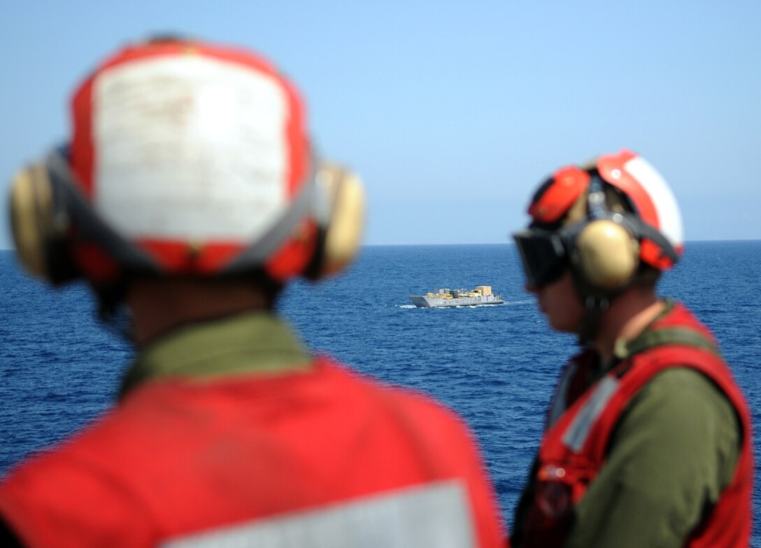 Lance Cpl. Eddie Asano, left, and Lance Cpl. Alex Cimino, Marine Attack Squadron 311 ordnance technicians, watch a landing craft unit approach the USS Peleliu off the coast of California April 16, 2010, during the squadron’s final predeployment exercise. Six AV-8B Harriers and approximately 80 squadron Marines left Yuma April 15 to participate in their third and final predeployment training evolution. The exercise, which began April 16 and is scheduled to end April 27, included the entire 15th Marine Expeditionary Unit. The squadron is slated to deploy to the Pacific and Indian Oceans with the 15th MEU in May. The remainder of the squadron deployed to Japan aboard the USS Essex with the 31st MEU in January. The last time the squadron deployed with the 15th MEU was in 2008.