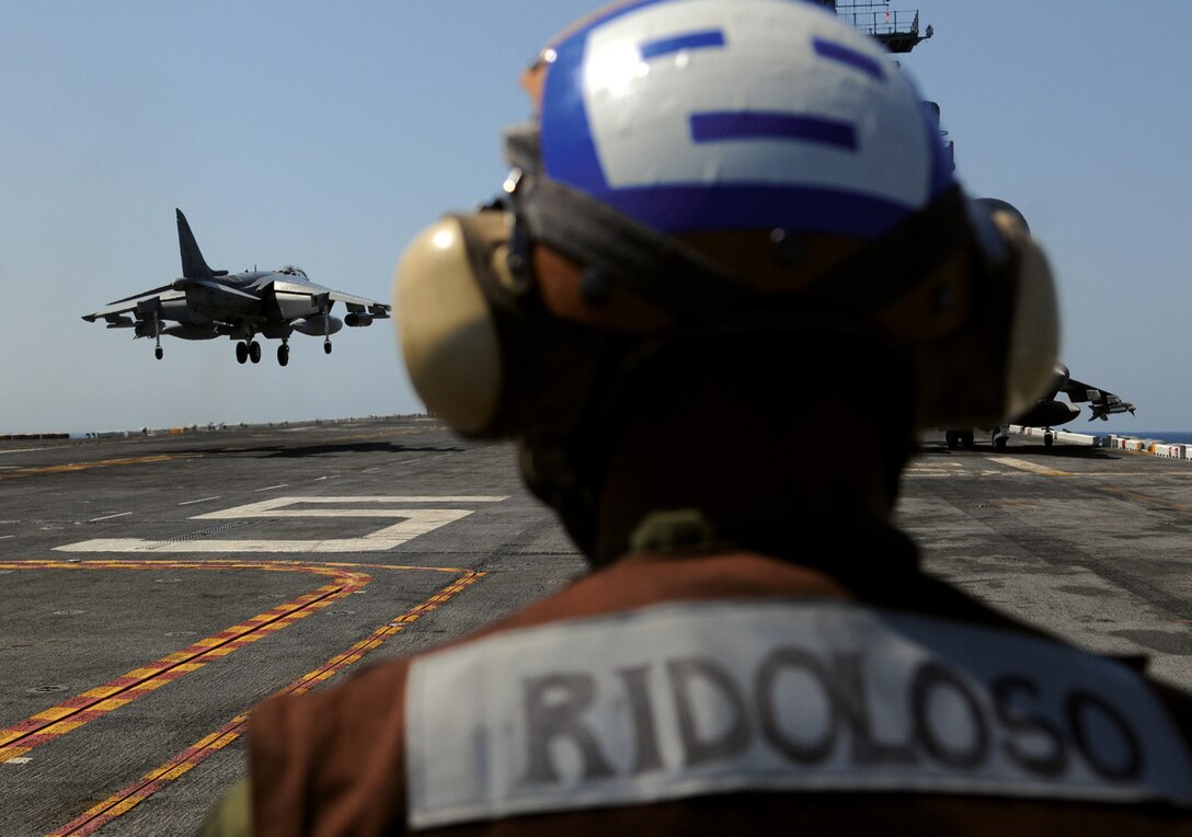 Lance Cpl. Mark Ridoloso, Marine Attack Squadron 311 powerline mechanic, watches Maj. Jason Egan, squadron pilot, land on the flight deck of the USS Peleliu April 16, 2010, during the squadron’s final predeployment exercise off the coast of California. Six AV-8B Harriers and approximately 80 squadron Marines left Yuma April 15 to participate in their third and final predeployment training evolution. The exercise, which began April 16 and is scheduled to end April 27, included the entire 15th Marine Expeditionary Unit. The squadron is slated to deploy to the Pacific and Indian Oceans with the 15th MEU in May. The remainder of the squadron deployed to Japan aboard the USS Essex with the 31st MEU in January. The last time the squadron deployed with the 15th MEU was in 2008.
