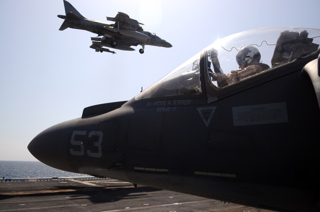Lt. Col. Robert Fails, Marine Attack Squadron 311 detachment commander, lands on the deck of the USS Peleliu as Capt. Anthony Hatala, squadron pilot, prepares to exit his AV-8B Harrier after flying from the Marine Corps Air Station in Yuma, Ariz., April 16, 2010. Six Harriers and approximately 80 squadron Marines left Yuma April 15 to participate in their third and final predeployment training evolution off the coast of California. The exercise, which began April 16 and is scheduled to end April 27, included the entire 15th Marine Expeditionary Unit. The squadron is slated to deploy to the Pacific and Indian Oceans with the 15th MEU in May. The remainder of the squadron deployed to Japan aboard the USS Essex with the 31st MEU in January. The last time the squadron deployed with the 15th MEU was in 2008.