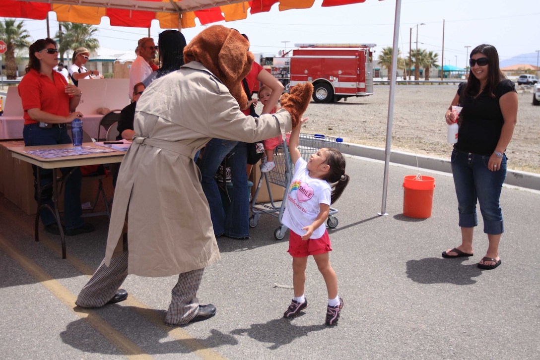 MARINE CORPS AIR GROUND COMBAT CENTER TWENTYNINE PALMS, Calif. - Scruff McGruff, the Crime Dog, gives a high-paw to Maribella Grotberg, 2, during the Family Fun Fitness Festival April 17 at the Commissary and Home Store parking lot. McGruff, along with representatives with California Highway Patrol, the San Bernardino County Sheriff's Department and the Provost Marshal's Office were at the festival to promote safety and encourage youngsters to "take a bite out of crime."