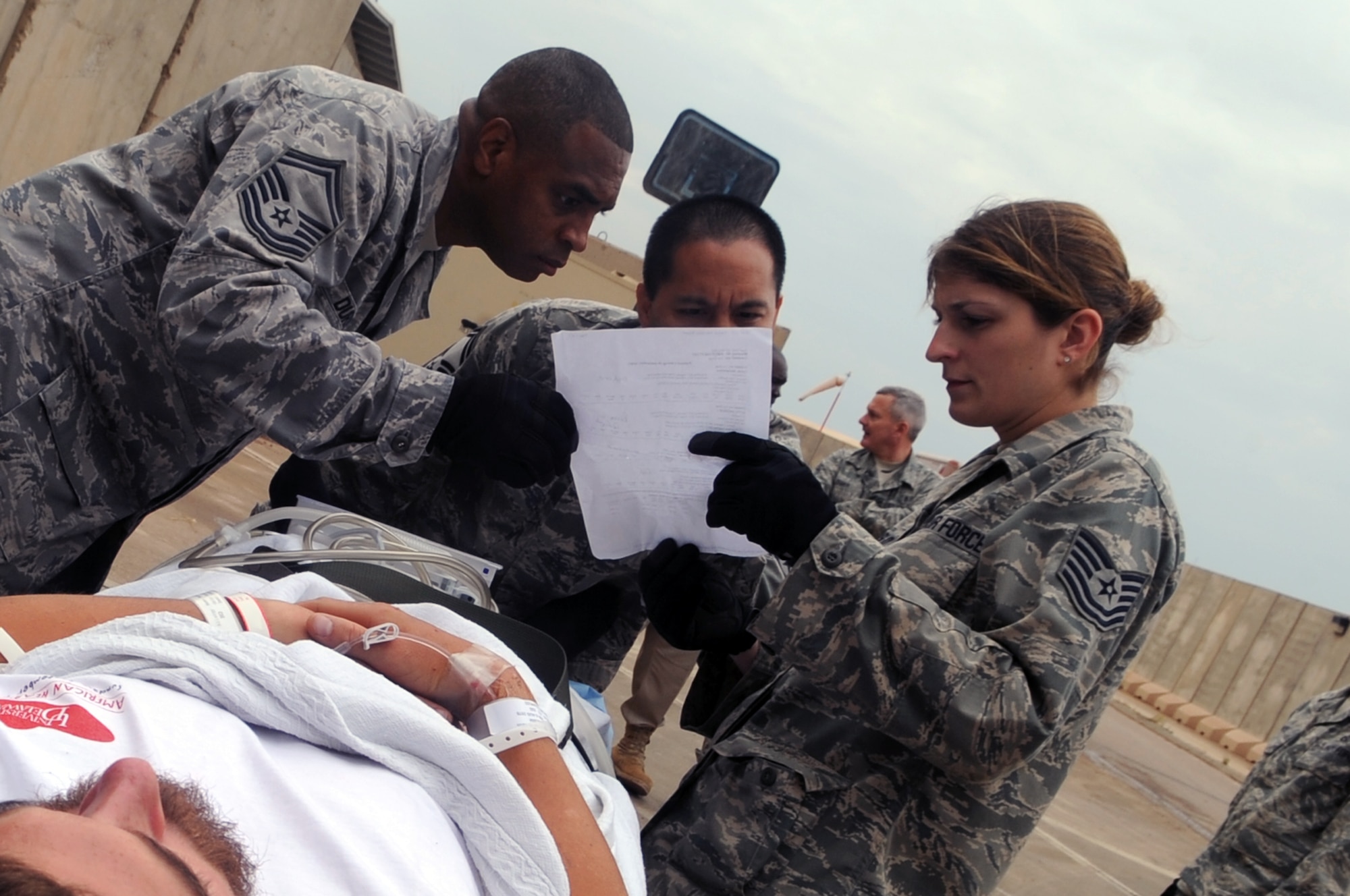 332nd Expeditionary Medical Group personnel look over a patient’s information before taking him inside the Air Force Theater Hospital during an aeromedical evacuation mission at Joint Base Balad, Iraq, April 17, 2010. The 332nd EMDG is expecting the average patient load to increase by about 50 patients per day. (U.S. Air Force photo/Senior Airman Brittany Y. Bateman/Released)