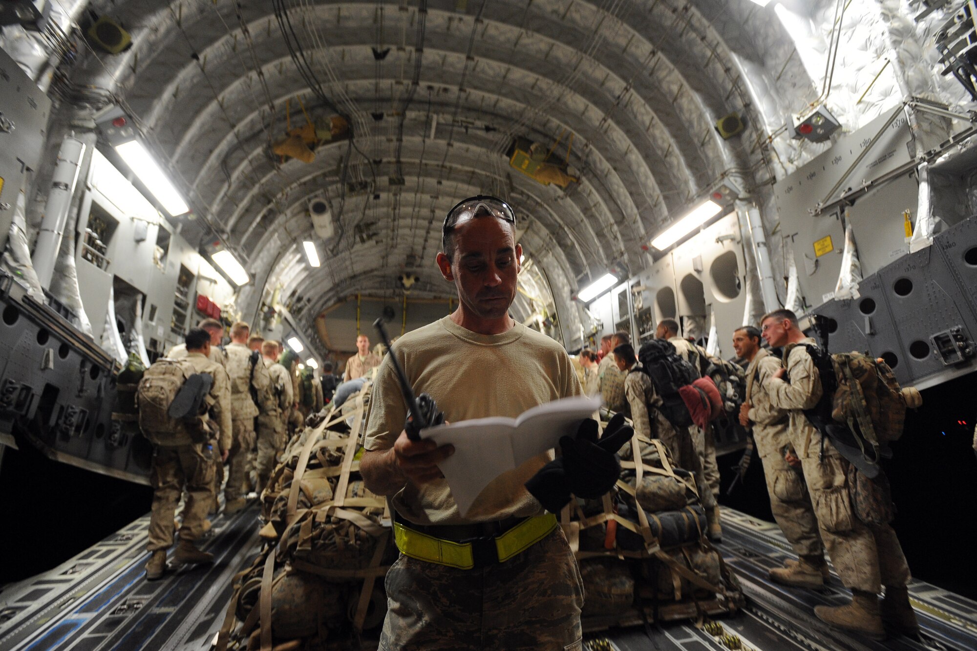 Staff Sgt. John Fitzgerald, a passenger-services agent assigned to the 451st Expeditionary Logistics Readiness Squadron, Detachment 1, checks paperwork as 157 Marines board a C-17A Globemaster III aircraft to fly to Camp Pendleton Calif., April 15, 2010, at Camp Bastion, Afghanistan. ?We see 200 to 300 customers a day, from Americans and Afghans going to forward locations to British and Danish servicemembers heading home,? said Sergeant Fitzgerald, deployed from Pope Air Force Base. ?We move the people who affect missions all over Afghanistan. It'is an awesome sight to witness and lets us know how much our job impacts the full spectrum of our operations over here.? (U.S. Air Force photo/Staff Sgt. M. Julian Martinez/released)