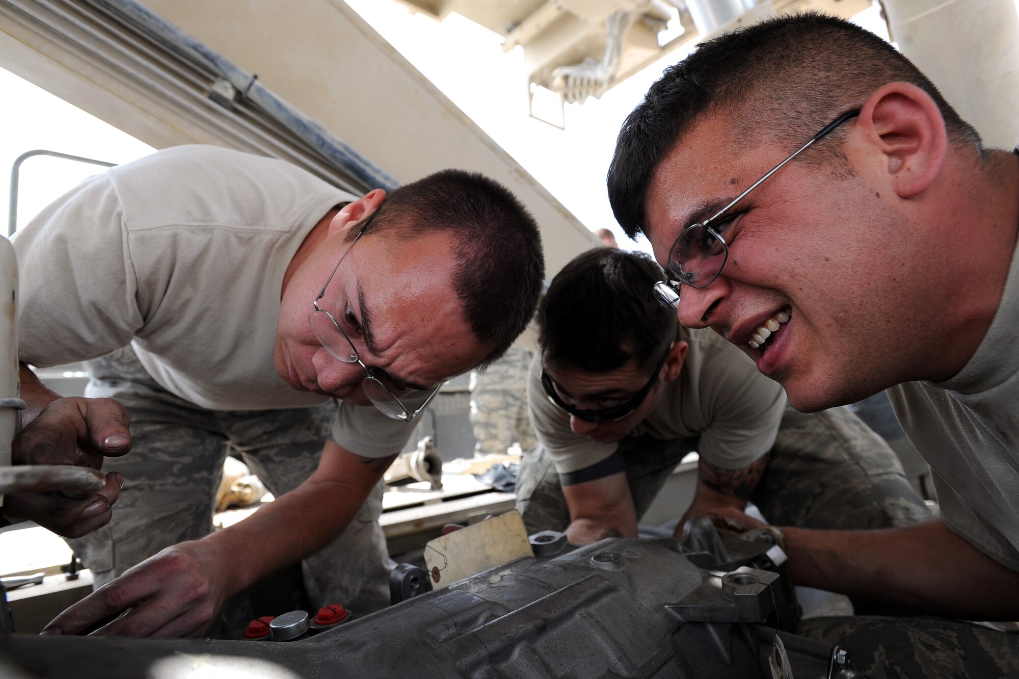 From left to right, Staff Sgts. Bryon Norton,Daniel Villela and Tech. Sgt. Joshua Schuldt, vehicle maintainers assigned to the 451st Expeditionary Logistics Readiness Squadron, Detachment 1, install a transmission into 25k fork lift, April 15, 2010, at Camp Bastion, Afghanistan. (U.S. Air Force photo/Staff Sgt. M. Julian Martinez/released)