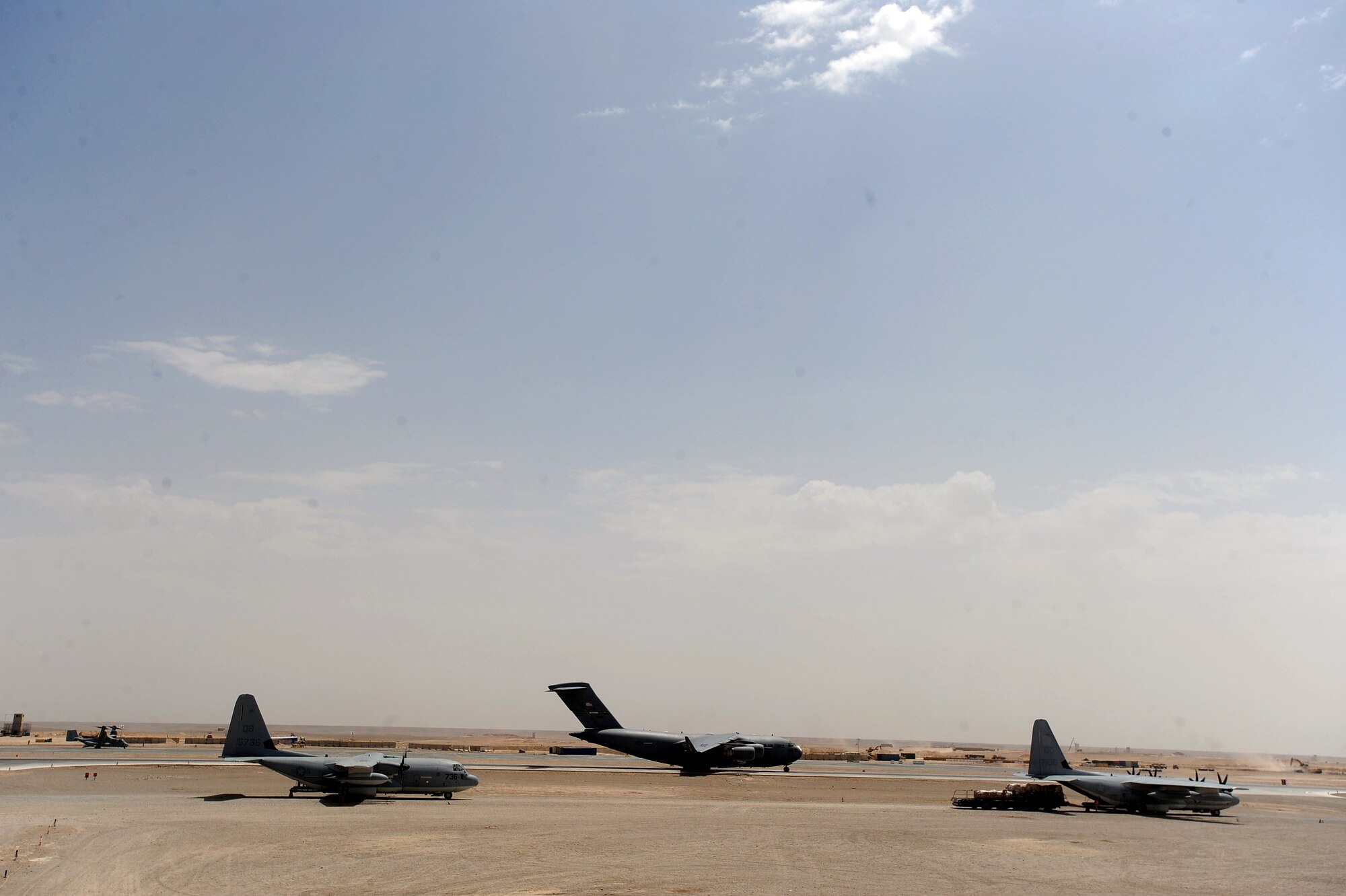 Two C-130 Hercules and a C-17 Globemaster at Camp Bastion, Afghanistan.  Aerial porters assigned to the 451st Expeditionary Logistics Readiness Squadron Det. 1,  load pallets on an outgoing C-130 Hercules with a 60K-loader, April 15, 2010, at Camp Bastion, Afghanistan. (U.S. Air Force photo/Staff Sgt. M. Julian Martinez/released)
