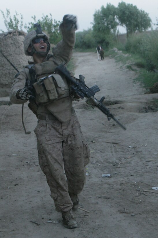 Cpl. Matthew T. Conley, a squad leader with Easy Company, 2nd Battalion, 2nd Marine Regiment, plays catch with a young local boy during a patrol to a local village near Patrol Base Khodi Rhom in Garmsir District, Helmand province, Afghanistan, April 19. Marines along side a section of Afghan National Army soldiers, man PB Khodi Rhom to patrol and observe an area once known for large amounts of enemy activity.