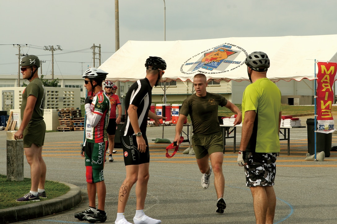 A participant passes his sash to his teammate during the Earth Day Tri-Ekiden Relay Race April 18. Once participants receive sashes, they are free to continue to the bike portion of the race.