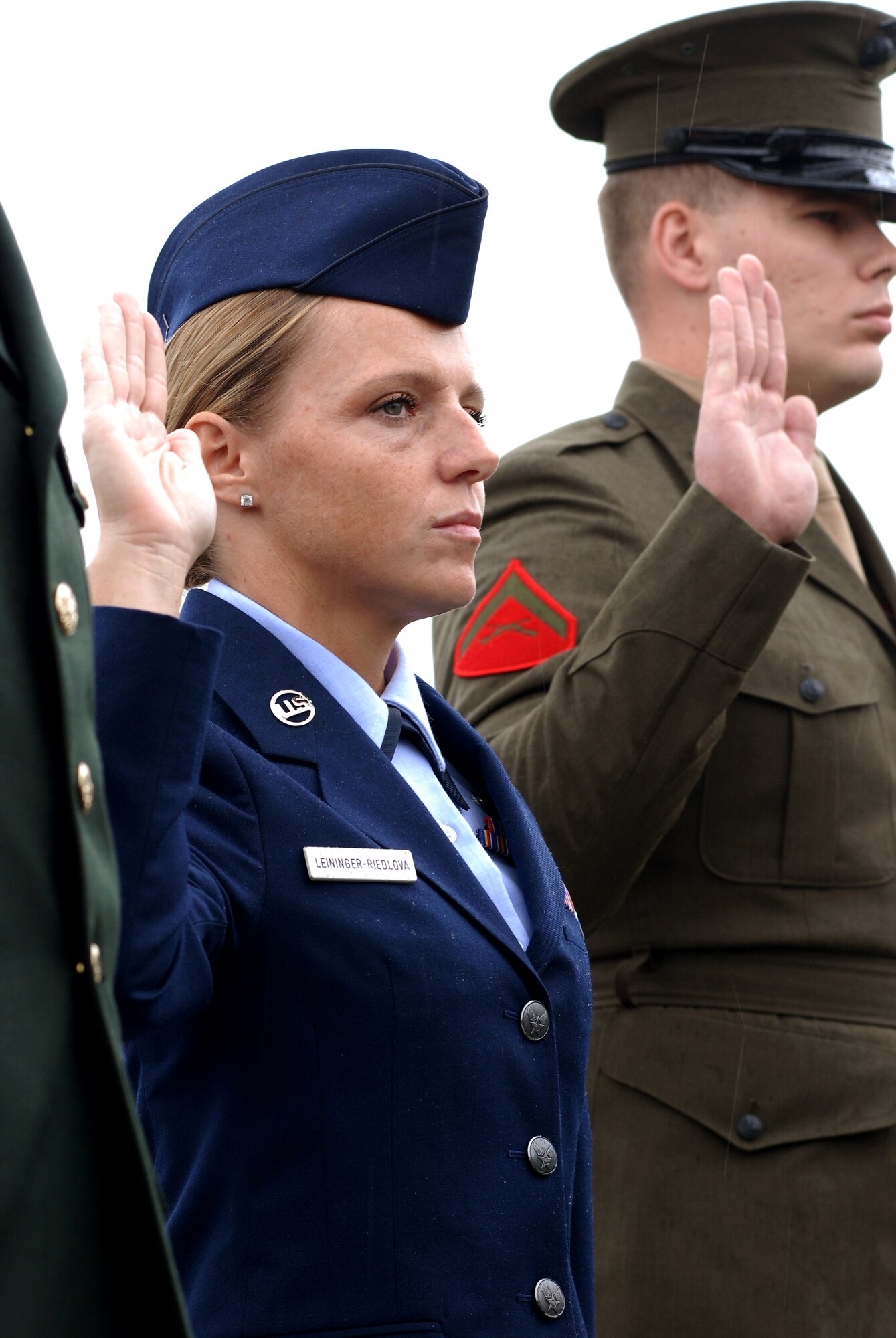 CAMP MABRY, Texas -- Under somber rainy skies, in front of a replica Vietnam Memorial Wall, 13 service members took the Oath of Allegiance to become American citizens
Among the new Americans was Senior Airman Ivanna Leininger-Riedlova, 74th Aerial Port Squadron, Lackland Air Force Base, Texas, who left behind her Czech citizenship
U.S. District Judge Lee Yeakel gave the Oath of Allegiance during the small ceremony, which was part of the weekend-long American Heroes Air Show here.
Airman Leininger-Riedlova said her husband, who is an Army medic, encouraged her to join the Air Force. "I was 32 when I enlisted in May '08 here in San Antonio," she said.
While she acknowledged it was difficult to leave the Czech Republic and never thought she would be an American citizen, she is glad she did. "I have goals," she said. "I want to be a linguist." Airman Leininger-Riedlova said, "I just wanted to be part of fighting for freedom." (U.S. Air Force photo/Airman 1st Class Brian McGloin)

