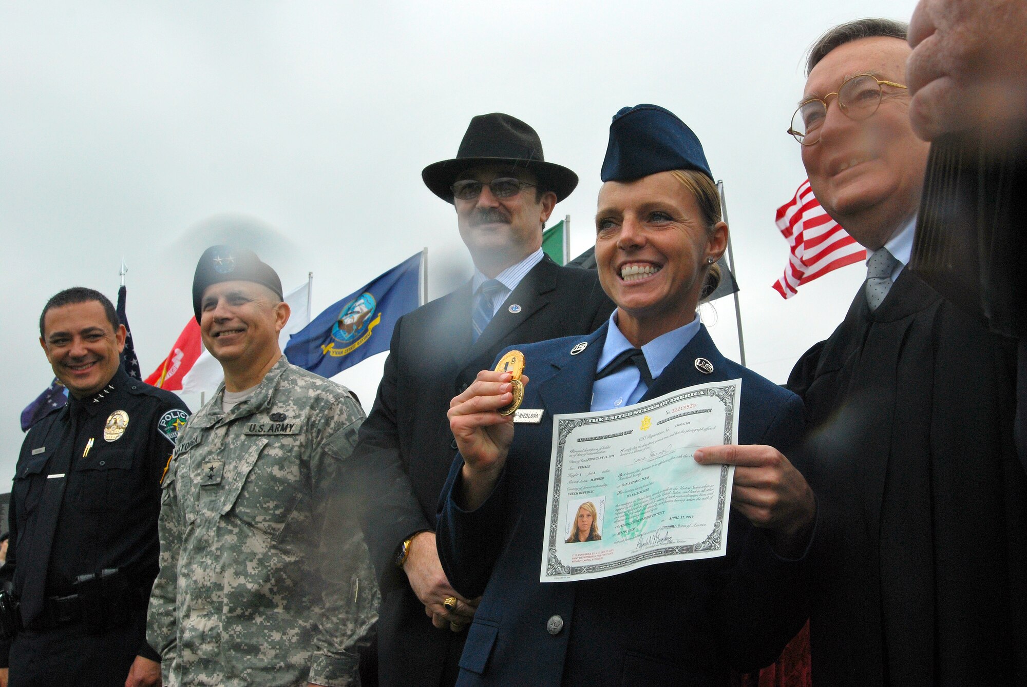 CAMP MABRY, Texas -- Under somber rainy skies, in front of a replica Vietnam Memorial Wall, 13 service members took the Oath of Allegiance to become American citizens
Among the new Americans was Senior Airman Ivanna Leininger-Riedlova, 74th Aerial Port Squadron, Lackland Air Force Base, Texas, who left behind her Czech citizenship
U.S. District Judge Lee Yeakel gave the Oath of Allegiance during the small ceremony, which was part of the weekend-long American Heroes Air Show here.
Airman Leininger-Riedlova said her husband, who is an Army medic, encouraged her to join the Air Force. "I was 32 when I enlisted in May '08 here in San Antonio," she said.
While she acknowledged it was difficult to leave the Czech Republic and never thought she would be an American citizen, she is glad she did. "I have goals," she said. "I want to be a linguist." Airman Leininger-Riedlova said, "I just wanted to be part of fighting for freedom." (U.S. Air Force photo/Airman 1st Class Brian McGloin)

