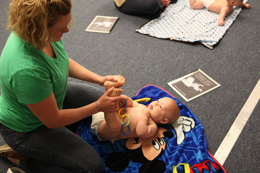 26th Marine Expeditionary Unit spouses learn how to give their newborns a message during a class April 19, 2010. The 26th MEU Family Readiness Program aims to enable every Marine and sailor to complete every assigned mission without the stress of being unsure about the well-being of loved ones on the home front. The infant massage instruction and other family wellness courses are just some of the ways 26th MEU encourages family readiness.