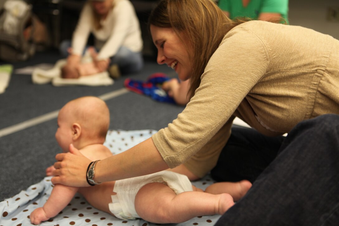26th Marine Expeditionary Unit spouses learn how to give their newborns a message during a class April 19, 2010. The 26th MEU Family Readiness Program aims to enable every Marine and sailor to complete every assigned mission without the stress of being unsure about the well-being of loved ones on the home front. The infant massage instruction and other family wellness courses are just some of the ways 26th MEU encourages family readiness.