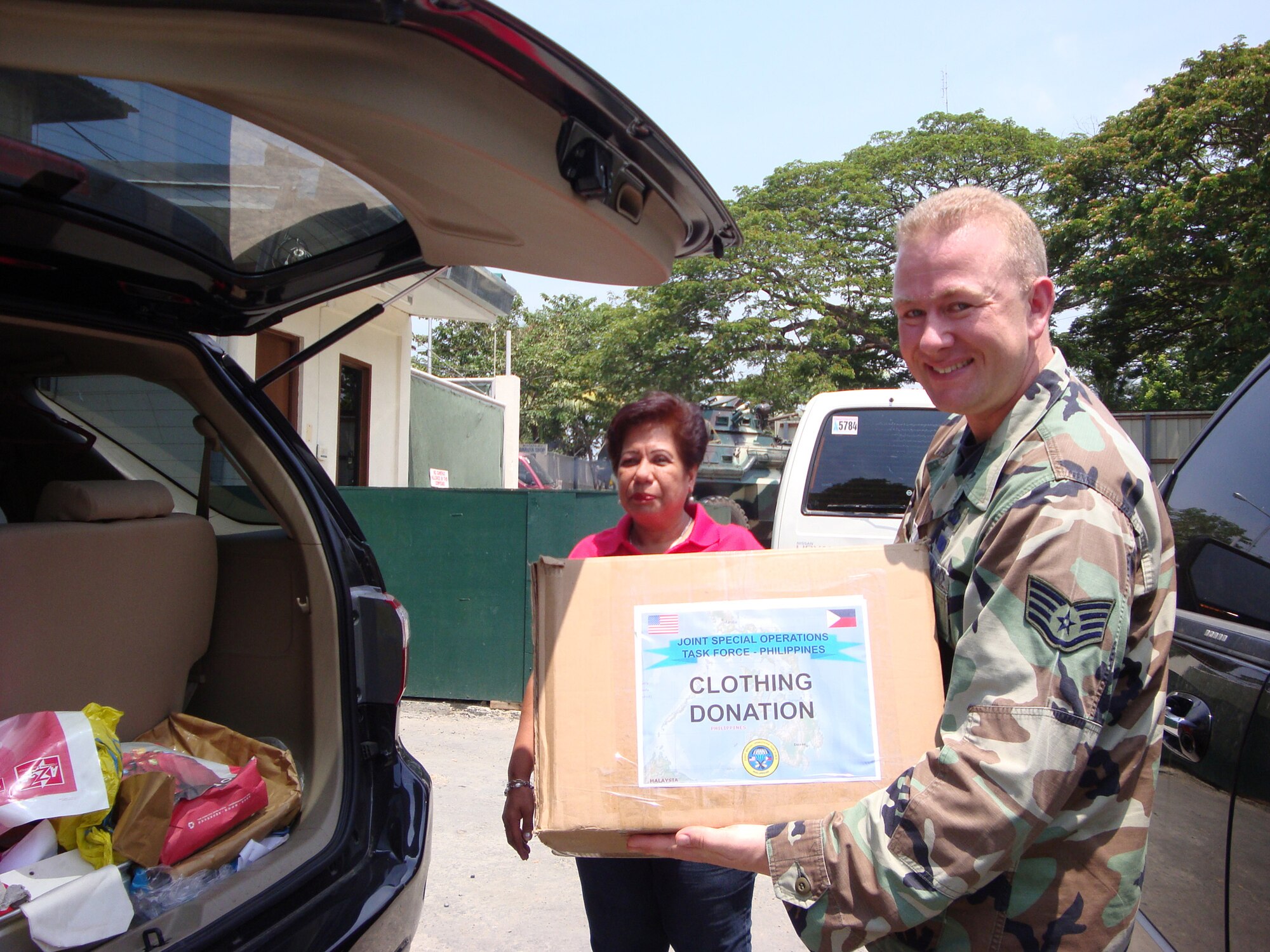 ZAMBOANGA CITY, Philippines -- Staff Sgt. David Buell, chaplain?s assistant, Joint Special Operations Task Force-Philippines hands over U.S. donated clothing, toiletries, toys, and school supplies to a representative from the Philippine Charity Sweepstakes Office in Zamboanga City.  Five families? homes were completely destroyed from a fire on April 12, 2010.  The JSOTF-P command chaplain?s office frequently partners with the Armed Forces of the Philippines chaplain representatives and accompanies them at orphanages, schools, and places of worship in local communities. (U. S.Air Force photo/ Lt. Col. Tracey Saiki)