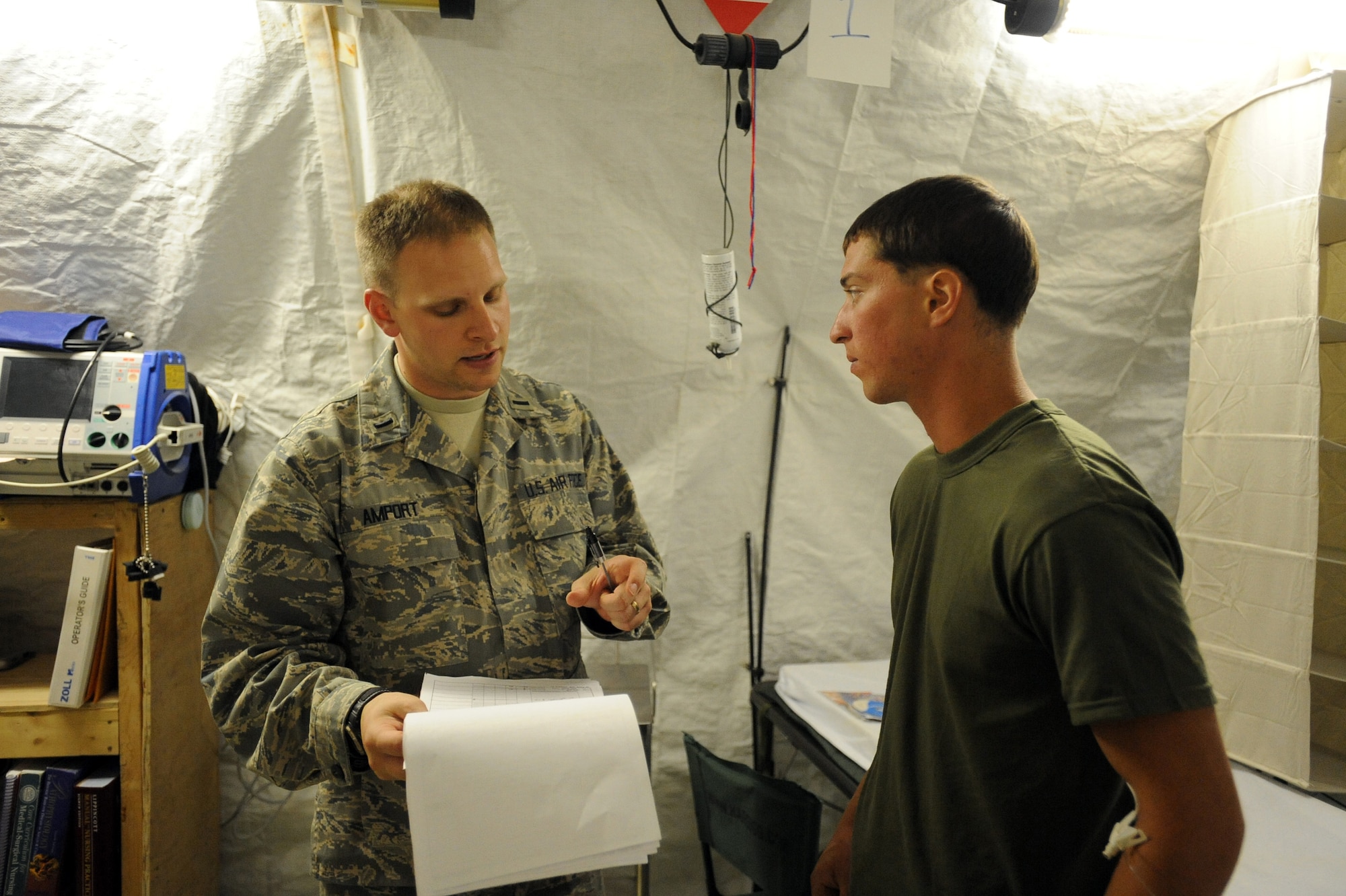 First Lieutenant Sean Amport, left, a registered nurse assigned to the 451st Expeditionary Aeromedical Evacuation Squadron, Detachment 1 Contingency Aeromedical Staging Facility, speaks with Marine Lance Cpl. Chris Spadaccini, assigned to 1/6 Marine Expeditionary Force, Bravo Company, 3rd Platoon about his injury, April 13, 2010, at Camp Bastion. (U.S. Air Force photo/Staff Sgt. Manuel J. Martinez)