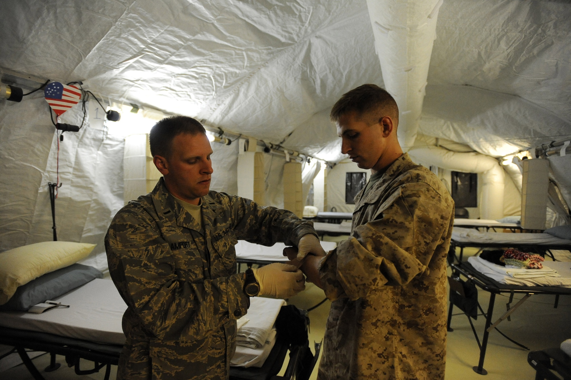 First Lieutenant Sean Amport, a registered nurse assigned to the 451st Expeditionary Aeromedical Evacuation Squadron, Detachment 1 Contingency Aeromedical Staging Facility, checks Marine Cpl. Jordan Martin's vitals in the CASF, April 13, 2010, at Camp Bastion, Afghanistan. (U.S. Air Force photo/Staff Sgt. Manuel J. Martinez/released)
