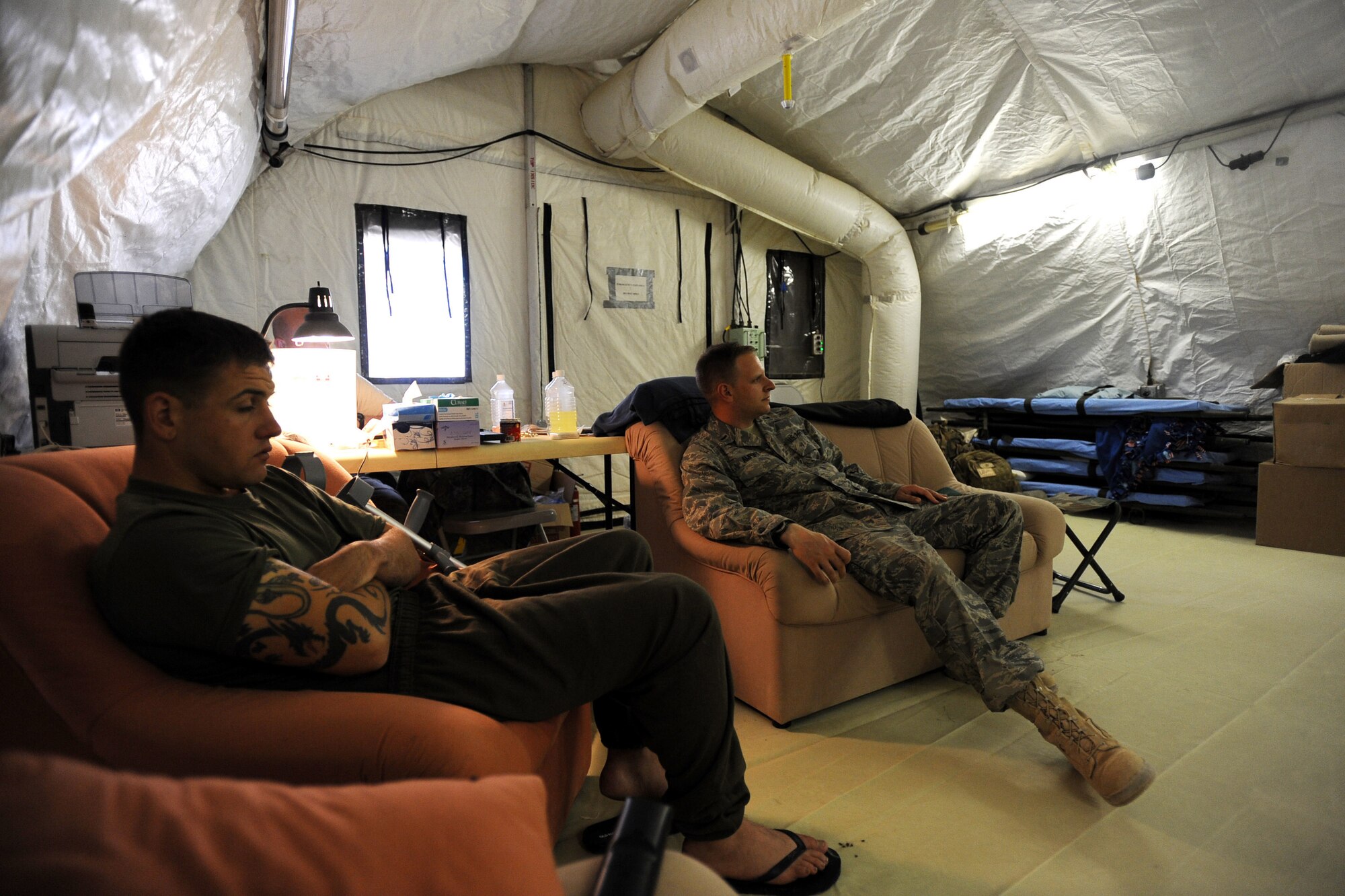 A Marine Corps patient and First Lieutenant Sean Amport, right, a registered nurse assigned to the 451st Expeditionary Aeromedical Evacuation Squadron, Detachment 1 Contingency Aeromedical Staging Facility (CASF), watch a movie in the facility's morale tent April 12, 2010, at Camp Bastion, Afghanistan. Since February 1 more than 515 patients have passed through the CASF. The 26 Airmen at the facility have assisted in the aeromedical evacuation of more than 340 patients. (U.S. Air Force photo/Staff Sgt. Manuel J. Martinez/released)