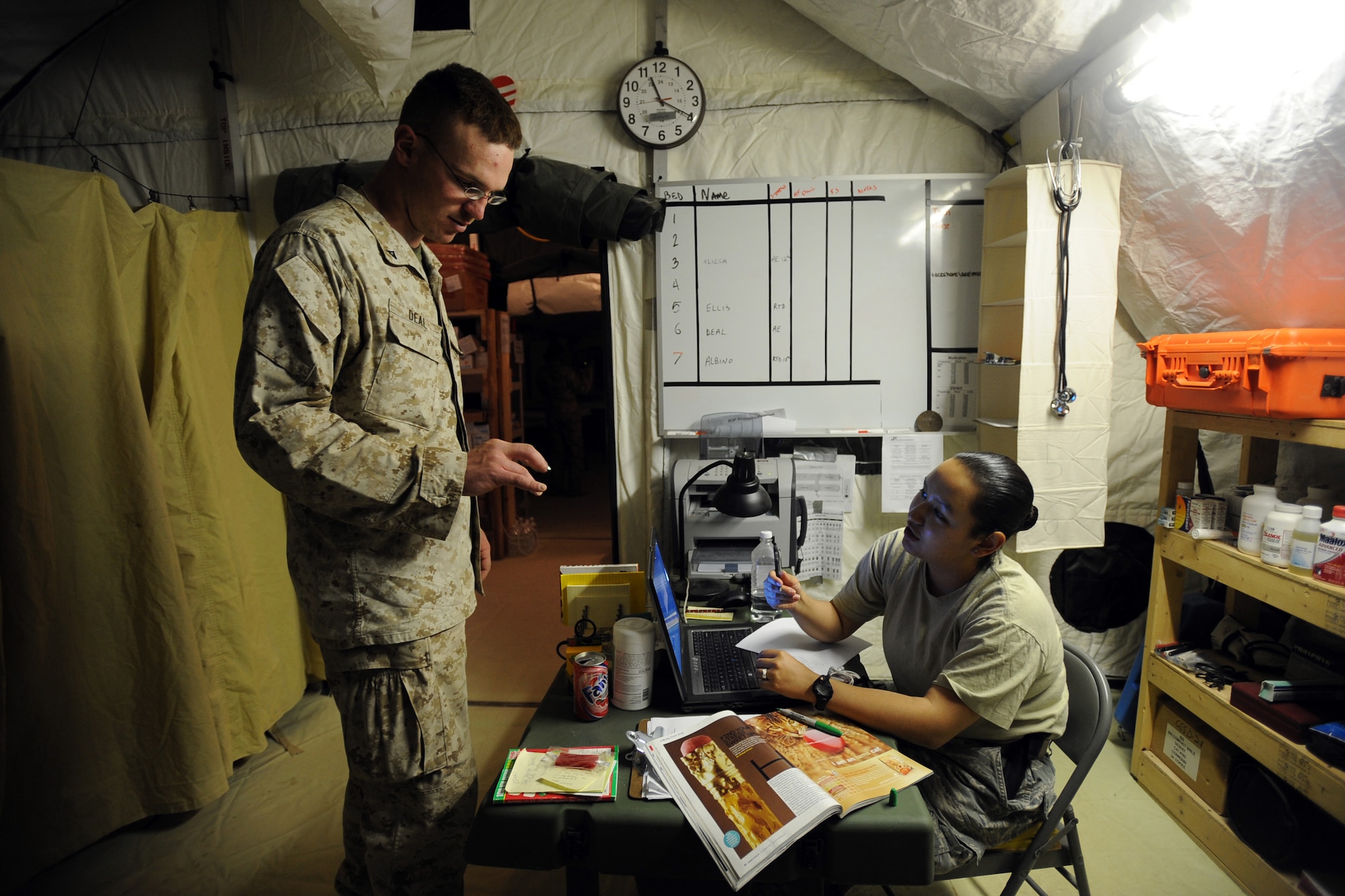 Marine Lance Cpl. Gregory Deal, assigned to Marine Wing Support Squadron, 274th Engineering Company, Heavy Equipment Platoon, and Senior Airman Magali Perez, an aerospace medical technician assigned to the 451st Expeditionary Aeromedical Evacuation Squadron, Detachment 1 Contingency Aeromedical Staging Facility, discuss how much his finger injury has affected his writing abilities, April 12, 2010, at Camp Bastion, Afghanistan. (U.S. Air Force photo/Staff Sgt. Manuel J. Martinez/released)