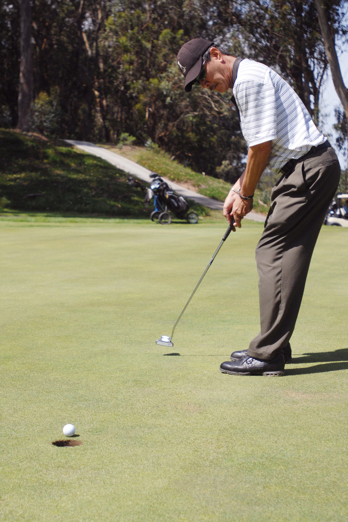 VANDENBERG AIR FORCE BASE, Calif. – Putting the ball, Benny Kurasima follows through with his shot during the Spring Open Golf Tournament at the Marshallia Ranch Golf Course here Sunday, April 18, 2010. The Spring Open is a two day tournament consisting of 36 holes. (U.S. Air Force photo/Senior Airman Christopher Hubenthal)