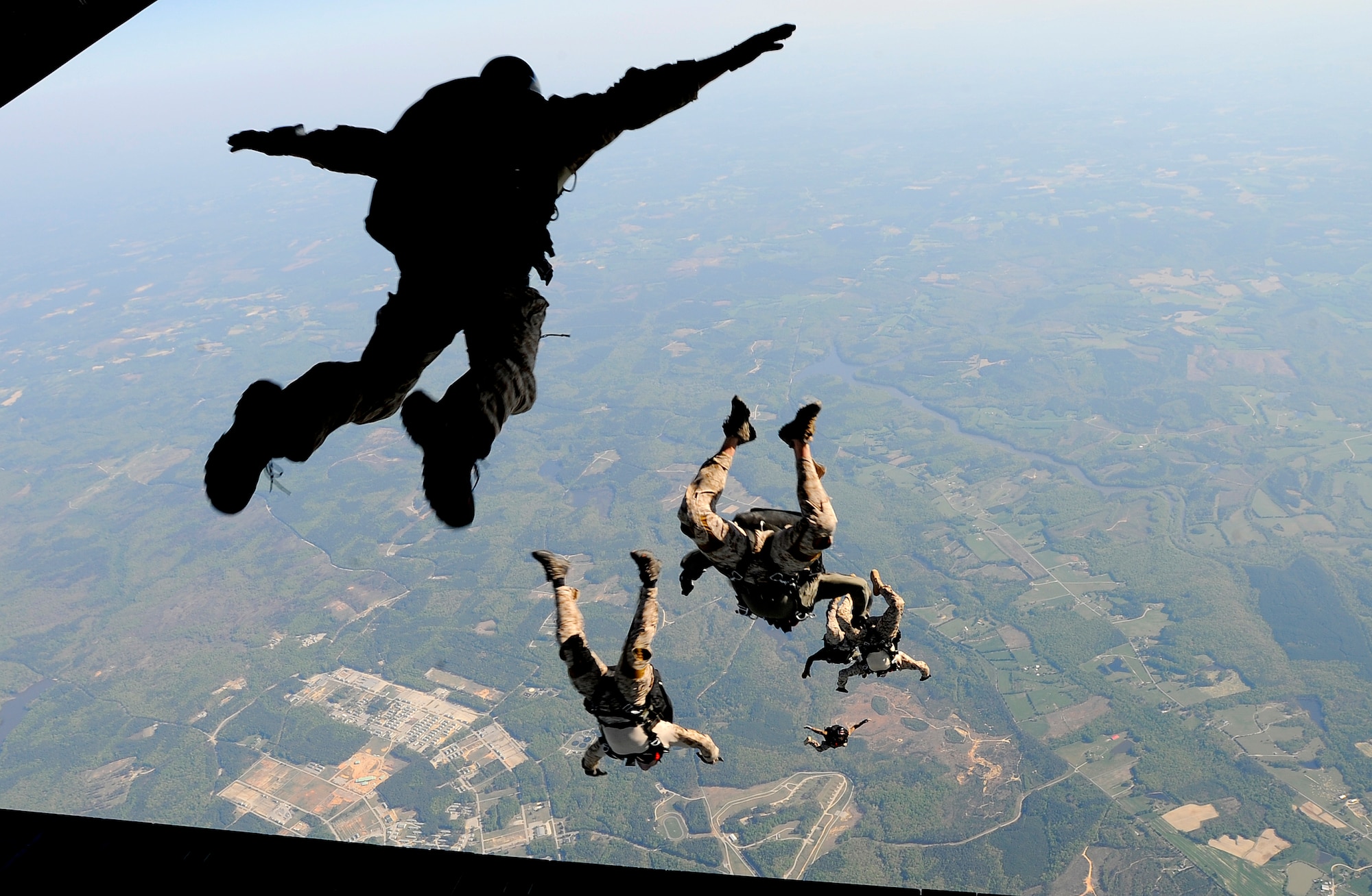 Navy SEALs jump from the ramp of a C-17 Globemaster III over Fort Picket Maneuver Training Center, Va., April 15.  The jump was part of joint training exercise with the 517th Airlift Squadron from Elmendorf Air Force Base, Alaska. The training consisted of high altitude, high opening and high altitude, low opening jumps between 5,000 and 12,500 feet. (Air Force photo by Staff Sgt. Brian Ferguson)