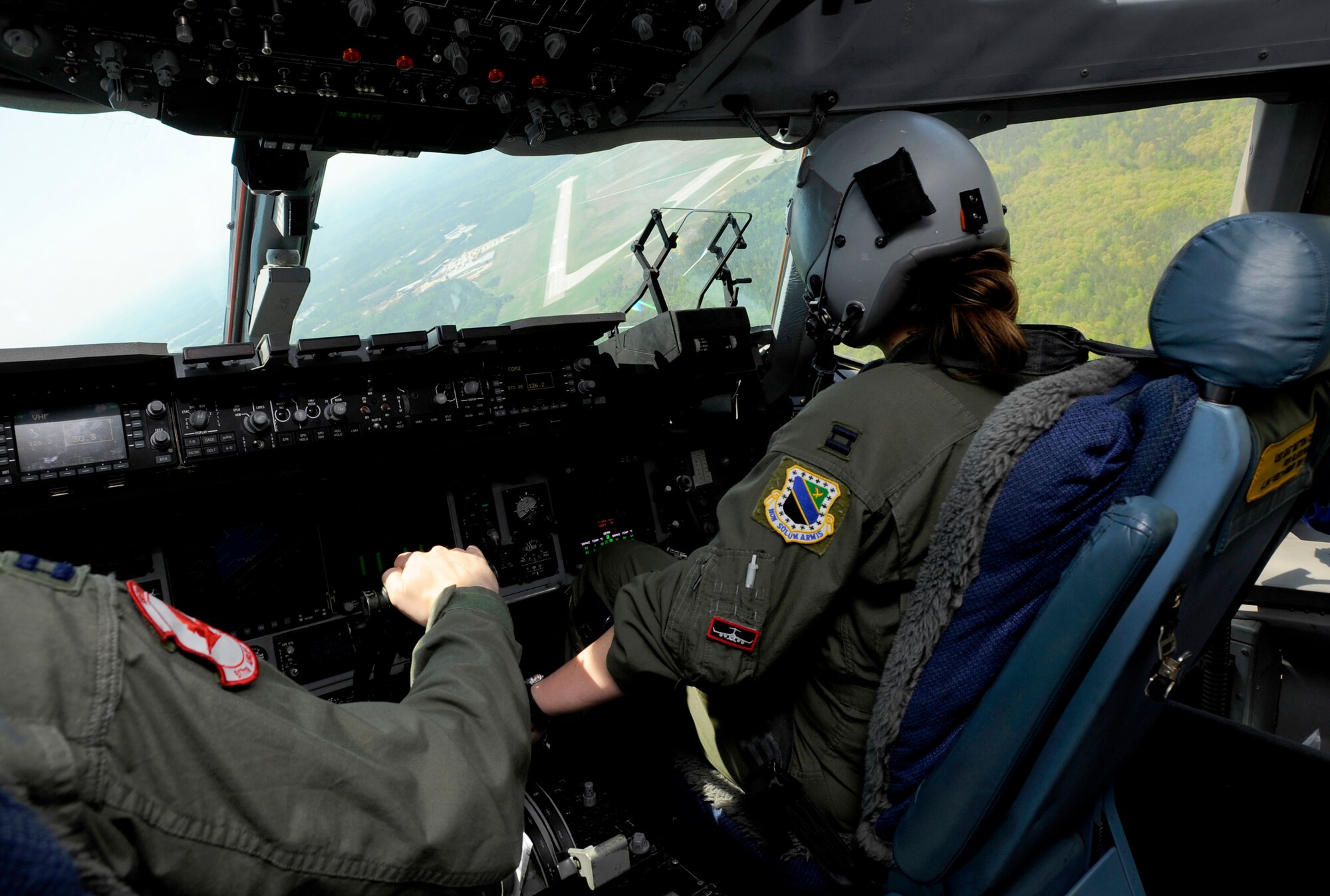 Capt. Adam Knox, left, and Capt. Jessica Reghi prepare to land a C-17 Globemaster III at Fort Picket Maneuver Training Center, Va., April 15. The plane landed to pick up a group of Navy SEALS during a joint training exercise with the 517th Airlift Squadron from Elmendorf Air Force Base, Alaska, and SEAL Team 10. The training consisted of high altitude, high opening and high altitude, low opening jumps between 5,000 and 12,500 feet. (Air Force photo by Staff Sgt. Brian Ferguson)