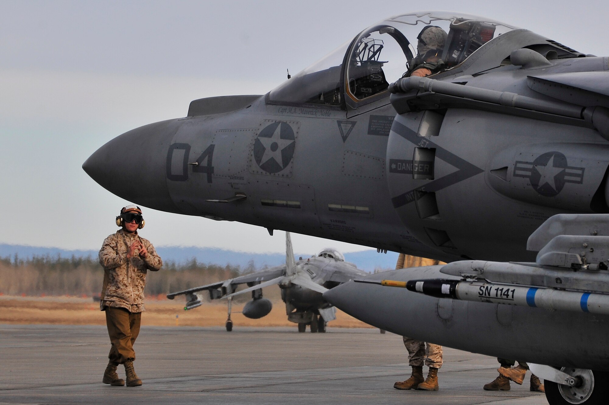 U.S. Marine Cpl. Kyle Loos marshals an AV-8B Harrier during RED FLAG-Alaska 10-2, April 19, 2010, Eielson Air Force Base, Alaska. RF-A provides unique opportunities to integrate various forces into joint, coalition, and bilateral training from simulated forward operating bases. Corporal Loos is assigned to VMA-211, Marine Corps Air Station, Yuma, AZ. (U.S. Air Force photo/Staff Sgt. Christopher Boitz)