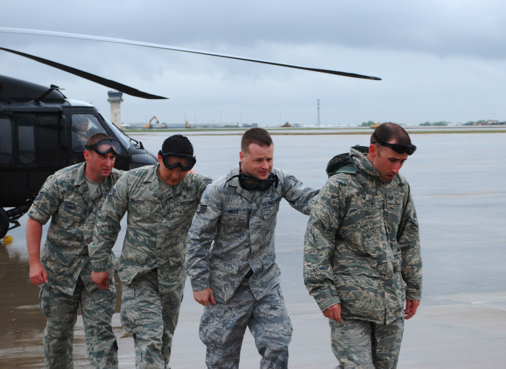 MCCONNELL AIR FORCE BASE, Kan. -- Tech. Sgt. Bret Parker and Staff Sgts. James Baluyot, Daniel Mills and Billy Cole (left to right), 22nd Medical Group, McConnell Air Force Base, Kan., practice egress procedures from a static UH-60Q Black Hawk helicopter during expeditionary medical readiness training April 16, 2010.  Later in the training, Airmen simulated loading and unloading "patients" with the helicopter rotors engaged in order to simulate the conditions they may experience in a deployed environment. (U.S. Air Force photo/2nd Lt. Nicholas Mercurio)