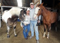 MINOT AIR FORCE BASE, N.D. – Staff Sgt. Keith Ballard (right), 5th Bomb Wing Public Affairs photographer, and his wife Carolyn, pose for a picture with their horses Sophie and Cash at the Dufresne Riding Club stables here March 22. According to Sergeant Ballard, horses are a great way to relax without all the stresses of daily life. (U.S. Air Force photo by Staff Sgt. Stacy Moless)