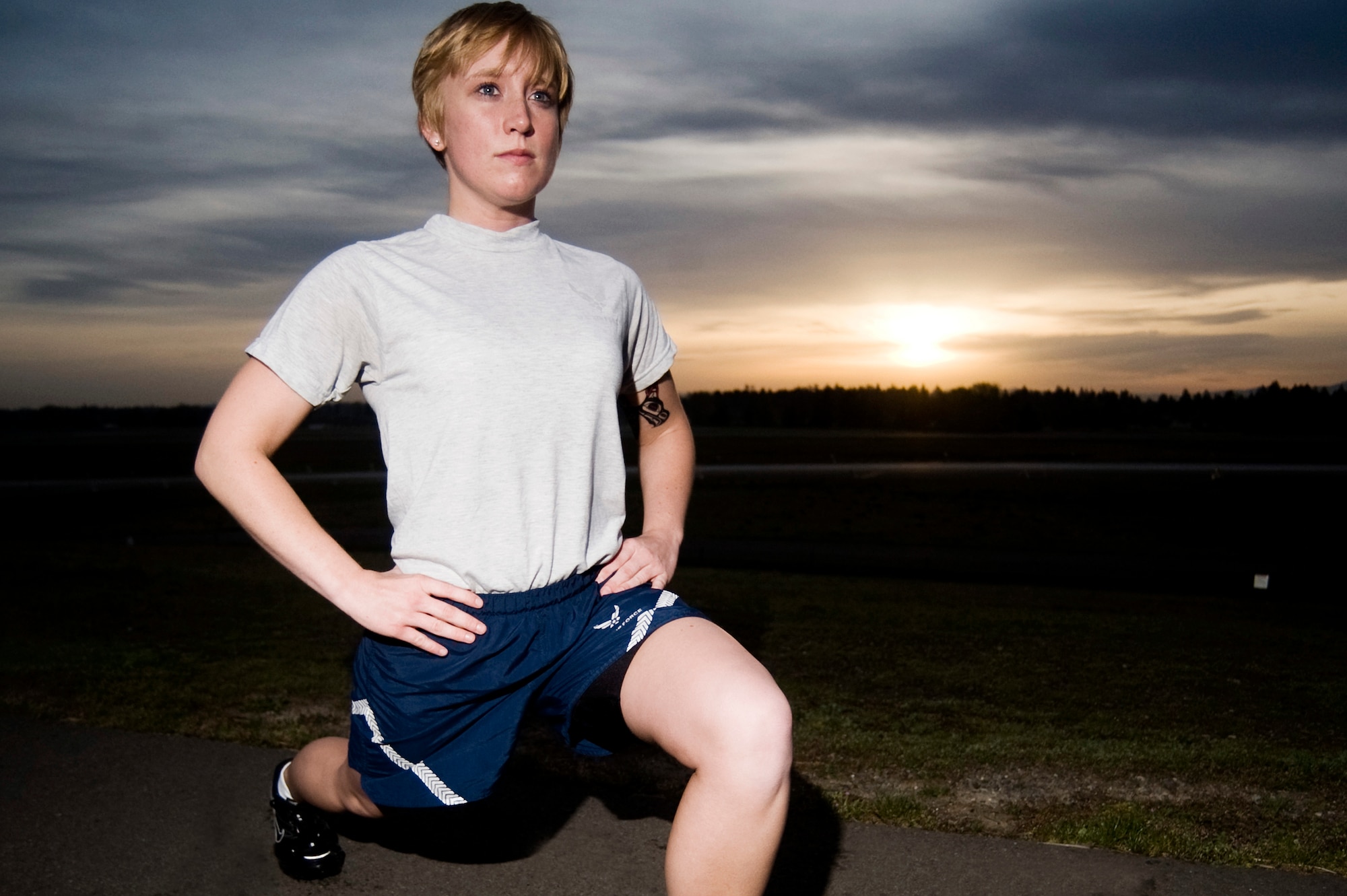 Senior Airman Angela Duff, 62nd Aerial Port Squadron, warms up with a set of lunges on Heritage Hill April 19 prior to a morning workout. (U.S. Air Force Photo by Abner Guzman)