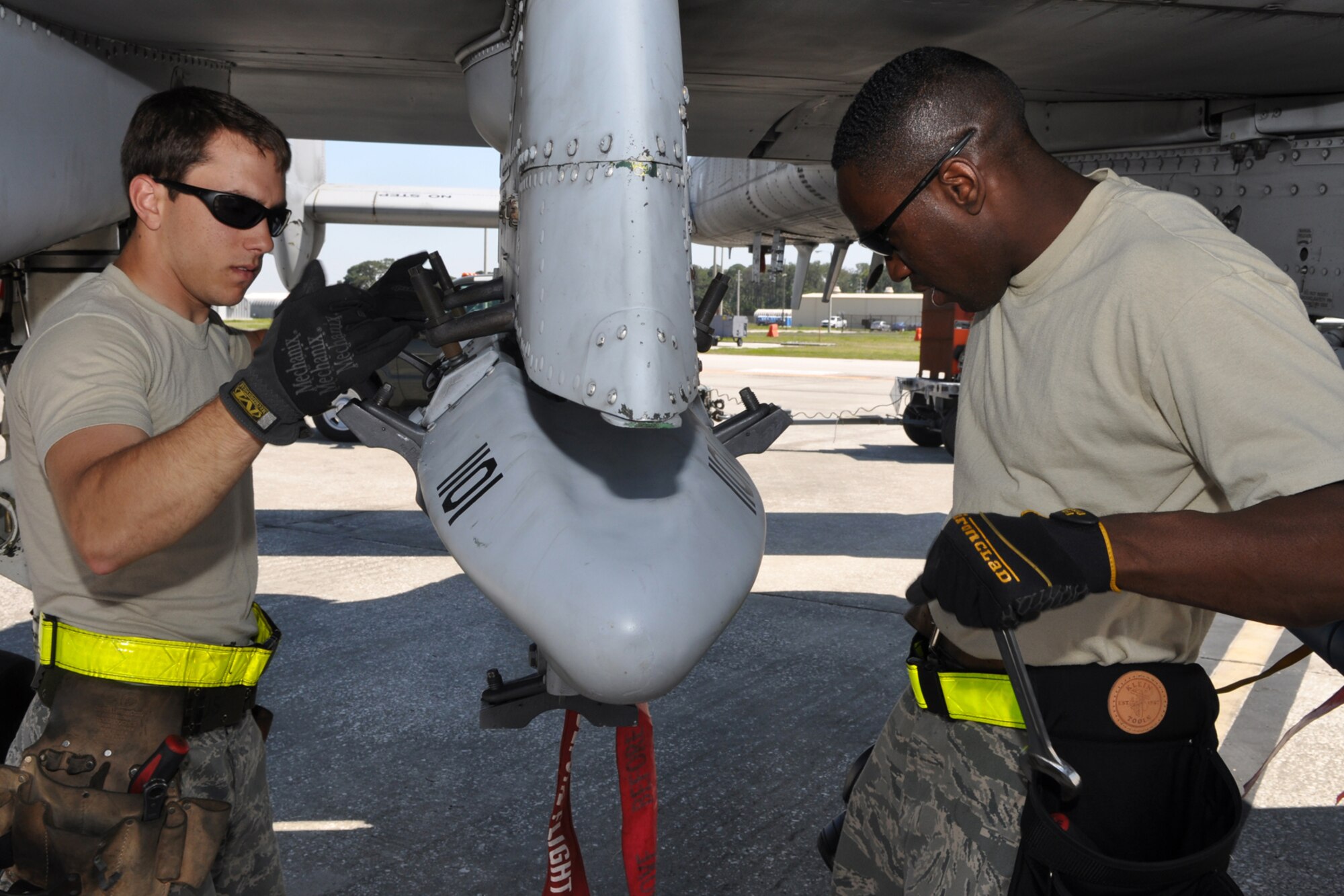 Senior Airman Josh Amburn and Charles Wilson, both aircraft armament systems mechanics with the 717th Aircraft Maintenance Squadron, from Barksdale Air Force Base, La., install a triple-ejection rack under the wing of an A-10 Thunderbolt II at MacDill Air Force Base, Fla., April 1, 2010. More than 100 Airmen from the 917th Wing, Barksdale Air Force Base, La., participated in Patriot Everglades, which supported the training of Joint Terminal Attack Controllers (JTAC) and Combat Search and Rescue (CSAR) operations. (U. S. Air Force Photo/Tech. Sgt. Jeff Walston)
