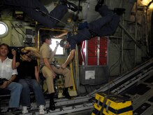 Loadmasters with the U.S. Navy Blue Angels team hold on tight during an incentive flight on a C-130 known as "Fat Albert" over the city of Charleston, S.C., April 16, 2010. During the flight, passengers experienced positive and negative gravity forces, which many said provided a stomach twisting experience. (U.S. Air Force Photo/Airman 1st Class Lauren Main)
