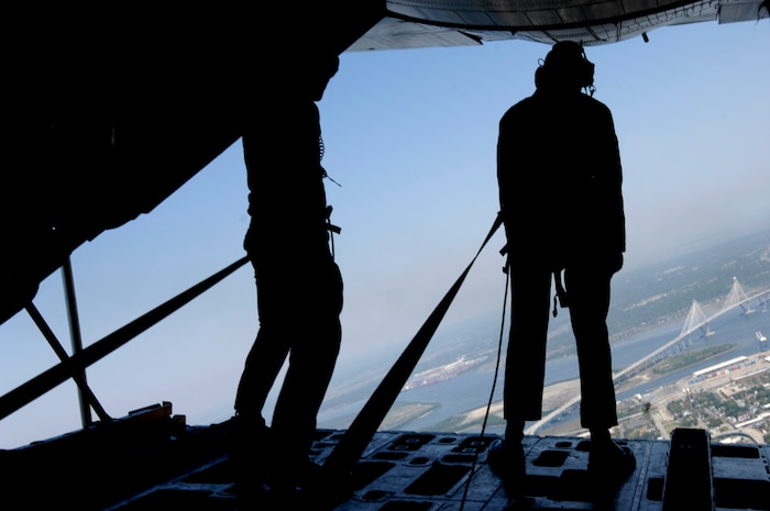 U.S. Navy loadmasters from the crew of the Blue Angels C-130 aircraft known as "Fat Albert" scan the scenery over the city of Charleston, S.C., during an incentive flight for local citizens April 16, 2010. The Blue Angels use the U.S. Marine Corps C-130T Hercules for logistics, carrying spare parts, equipment and to carry support personnel between shows. (U.S. Air Force Photo/Airman 1st Class Lauren Main)