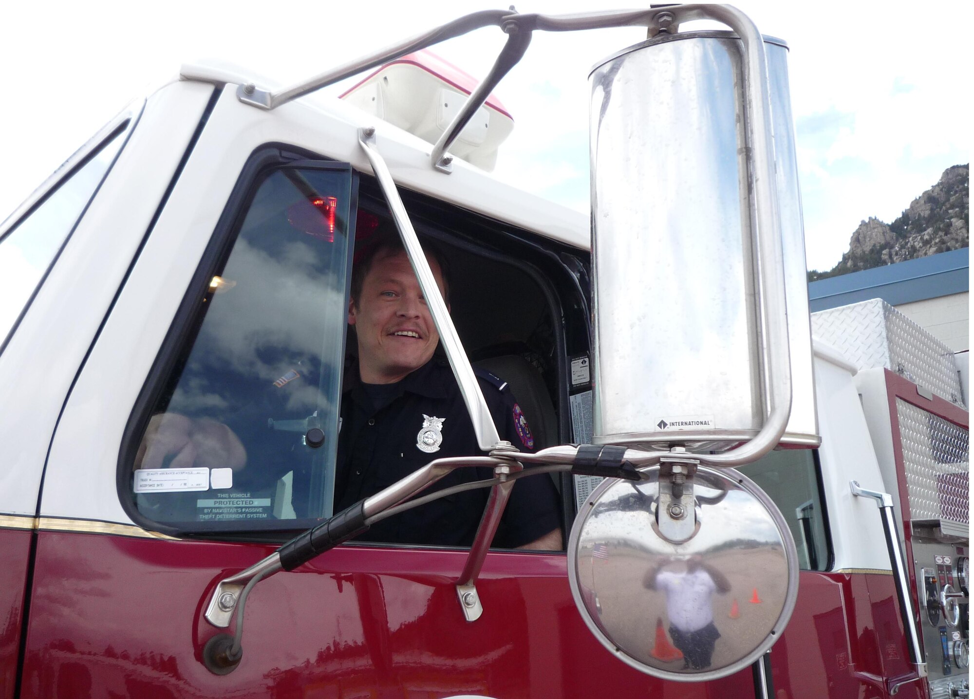 Chris Smith, Cheyenne Mountain AFS firefighter, smiles while driving a mutual aid partner’s fire engine during the emergency vehicle operator’s course. (U.S. Air Force photo/ Christopher Soliz)
