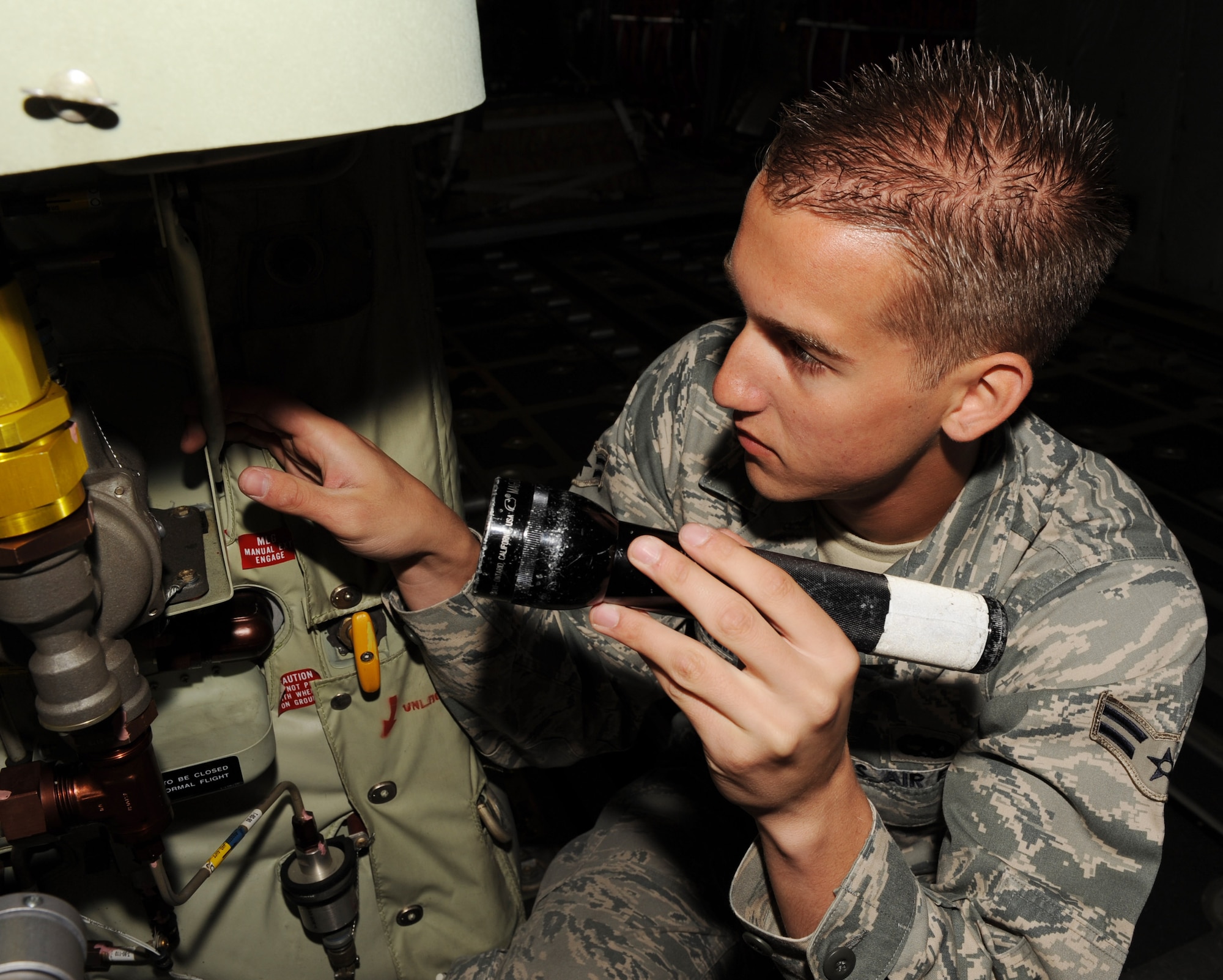 Airman 1st Class Justin Sliter, 314th Aircraft Maintenance Squadron crew chief, checks the hydraulic lines of a C-130J for leaks and cracks April 19. Airman Sliter worked outside his career field by assisting engineer technicians with the replacement of a propeller. They returned the aircraft to fully mission capable status in less than six hours. (U.S. Air Force photo by Staff Sgt. Chad Chisholm)