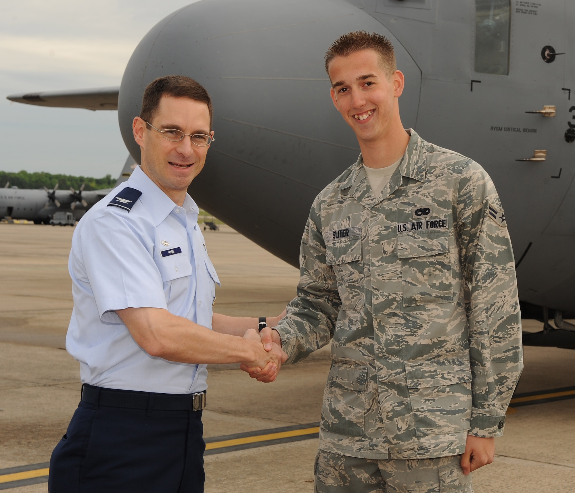 Col. C. K. Hyde, 314th Airlift Wing commander, presents a coin to Airman 1st Class Justin Sliter, 314th Aircraft Maintenance Squadron crew chief, April 19 for his selection as the Combat Airlifter of the Week. Airman Sliter is currently enrolled in two college classes, working toward a Professional Aeronautics degree with a 4.0 grade point average. (U.S. Air Force photo by Staff Sgt. Chad Chisholm)