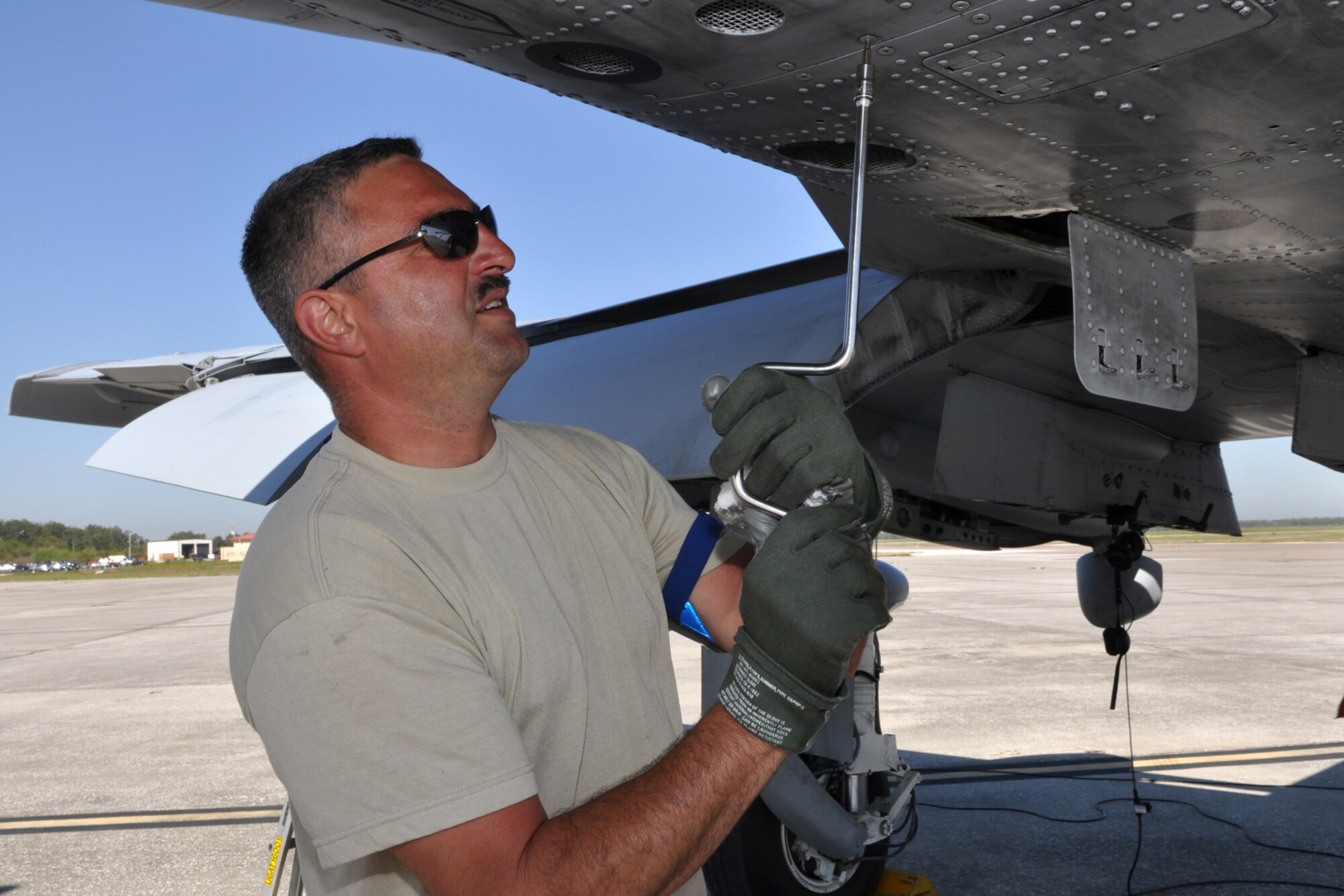 Master Sgt. Dave Long, aircraft electronics and environmental systems mechanic with the 717th Aircraft Maintenance Squadron, tightens a few loose panel screws he discovered while wiping excess hydraulic fluid from the fuselage of an A-10 Thunderbolt II during a pre-flight inspection at MacDill Air Force Base, Fla., April 1, 2010. More than 100 Airmen from the 917th Wing, Barksdale Air Force Base, La., participated in Patriot Everglades, which supported the training of Joint Terminal Attack Controllers (JTAC) and Combat Search and Rescue (CSAR) operations.    (U. S. Air Force Photo/Tech. Sgt. Jeff Walston)