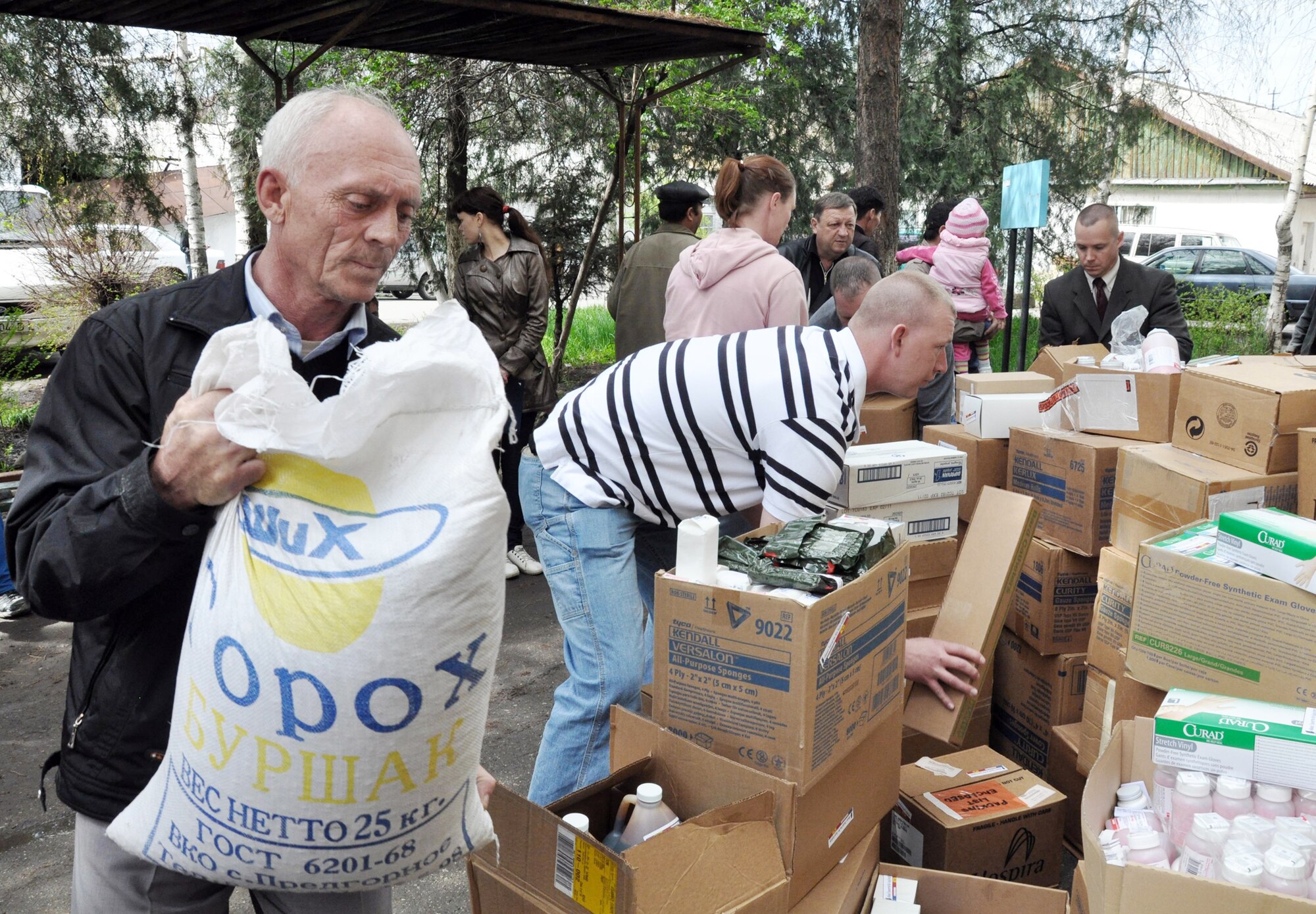 A Kyrgyz man helps Airmen from the Transit Center at Manas carry donated food and medical supplies April 15, 2010, for the National Hospital in Bishkek, Kyrgyzstan. (U.S. Air Force photo/Staff Sgt. Carolyn Viss)