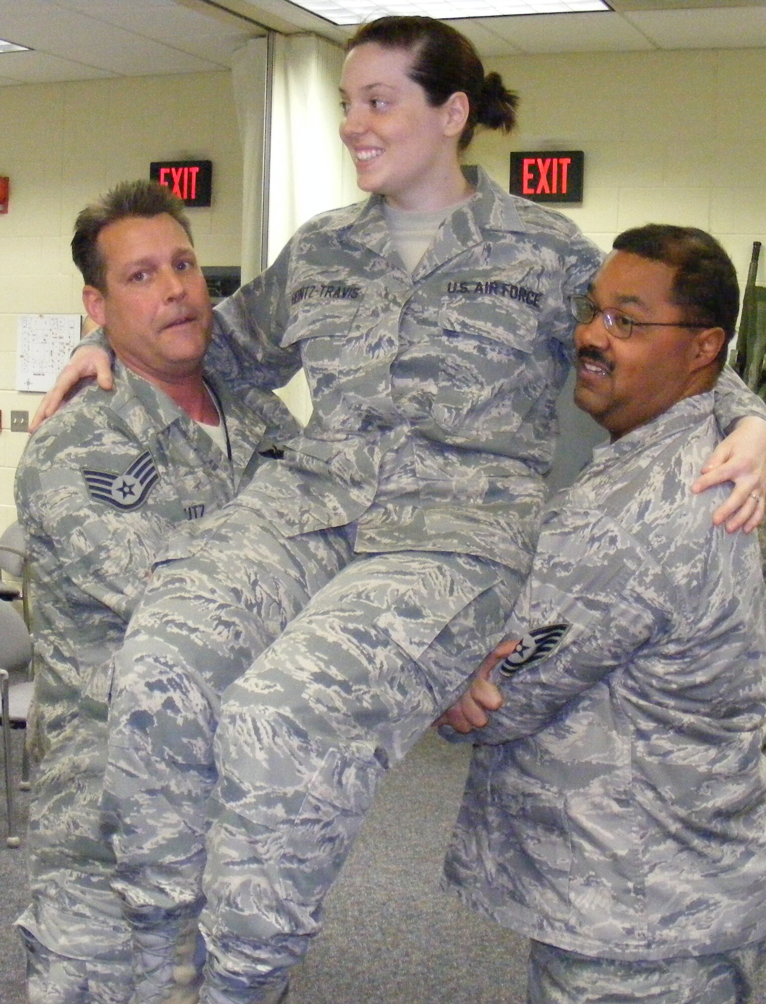 Staff Sgt. John Houtz, Senior Airman Kyrie Heintz-Travis, 779th Medical Group instructor and Technical Sgt. Alonzo Taylor, 459 Security Forces Squadron self-aid and buddy care advisor, conduct various personnel carrying techniques during a pre-deployment, self-aid and buddy care training session for the 69th Aerial Port Squadron recently. (U.S. Air Force/TSgt. Alonzo Taylor)