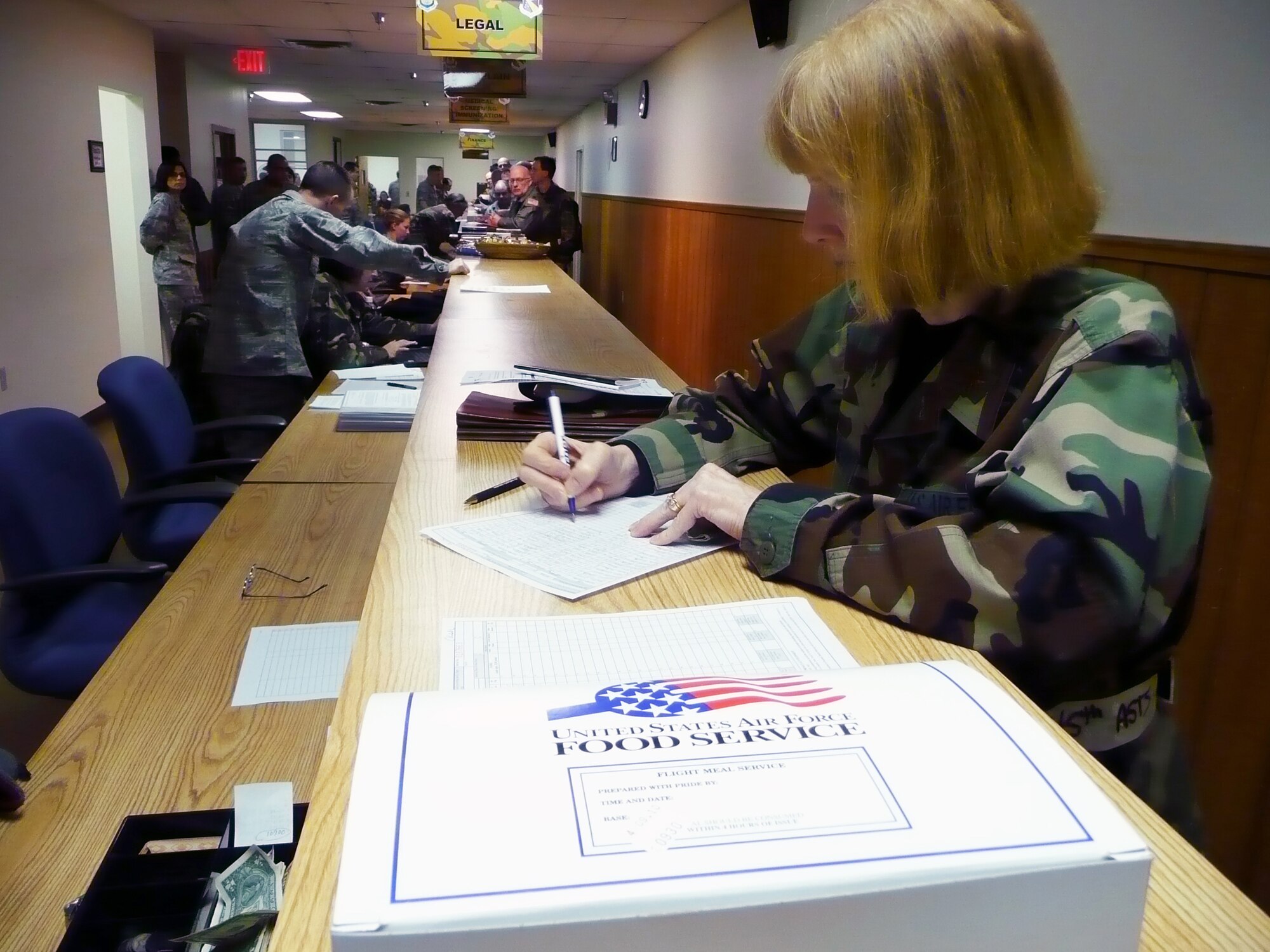 WRIGHT-PATTERSON AIR FORCE BASE, Ohio – Maj. Margaret Myslinsky. 445th Aeromedical Staging Squadron, signs for an inflight meal while processing through the mobility line during a wing exercise held during the April 10 unit training assembly. The exercise was partnered with the 88th Air Base Wing. (U.S. Air Force photo/Tech. Sgt. Jeremy Caskey)