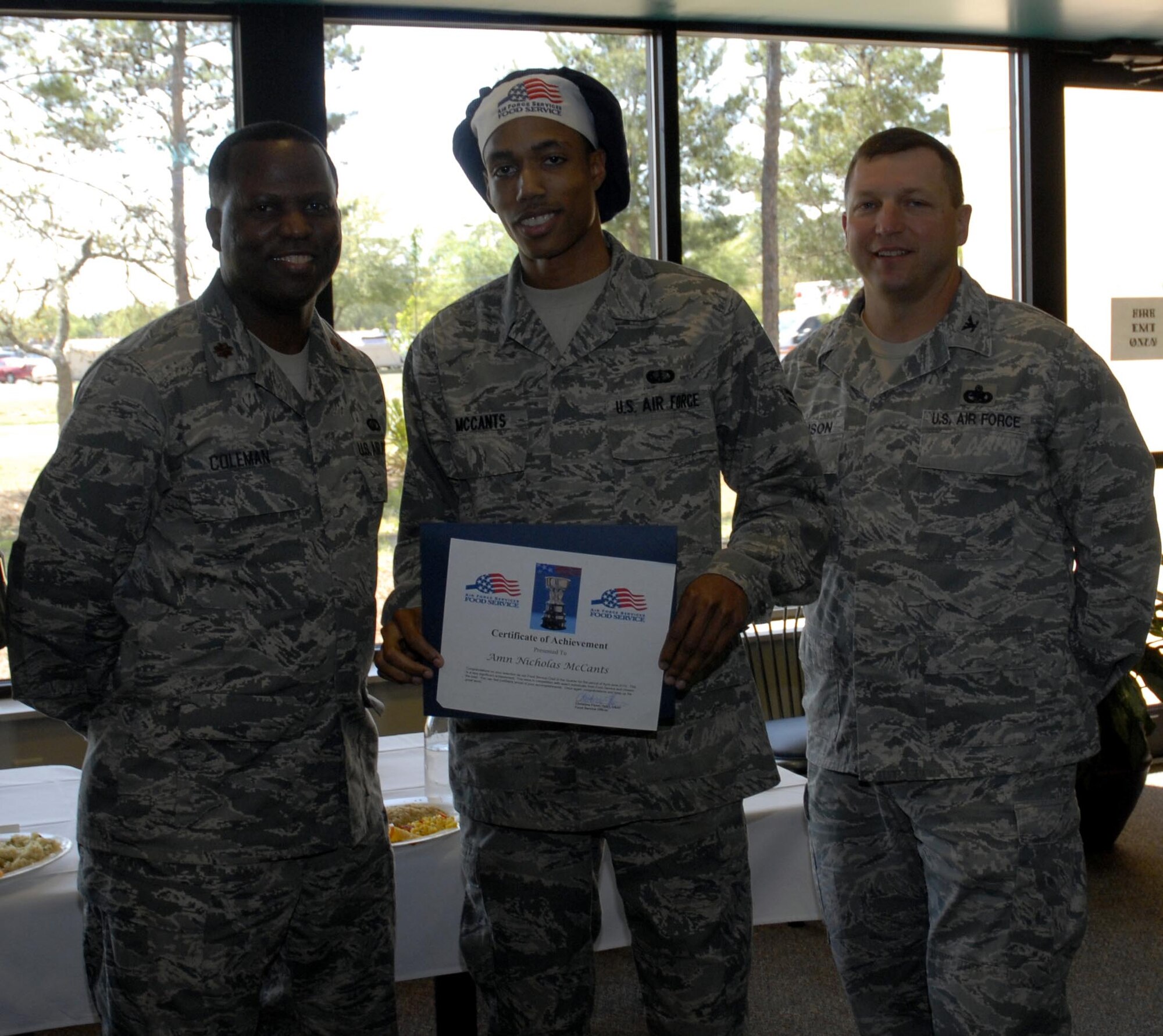 Col. Mark Johnson, 1st Special Operations Mission Support Group commander, right, and Maj. Lamont Coleman, 1st Special Operations Force Support Squadron commander, left, pose with Airman 1st Class Nicholas McCants, center, after he won the chef of the quarter competition at the Riptide dining facility at Hurlburt Field April 13. A panel of four judges sampled the dishes and picked them based on their taste, presentation, creativity and originality. (DoD photo by U.S. Air Force Airman 1st Class Joe McFadden) (Released)