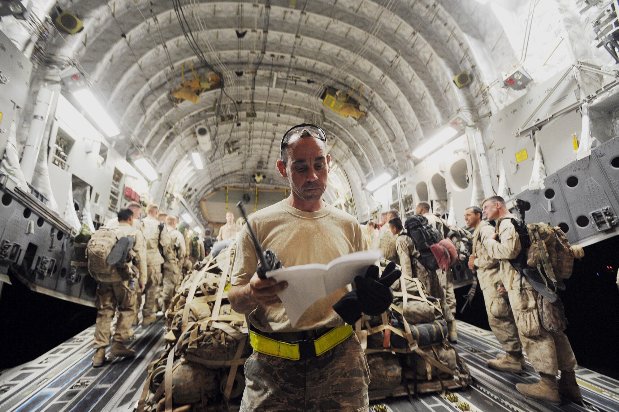 Staff Sgt. John Fitzgerald checks paperwork as 157 Marines board a C-17 Globemaster III aircraft to fly to Camp Pendleton Calif., April 15, 2010, at Camp Bastion, Afghanistan. Sergeant Fitzgerald is a passenger-services agent assigned to the 451st Expeditionary Logistics Readiness Squadron Det. 1. (U.S. Air Force photo/Staff Sgt. M. Julian Martinez)