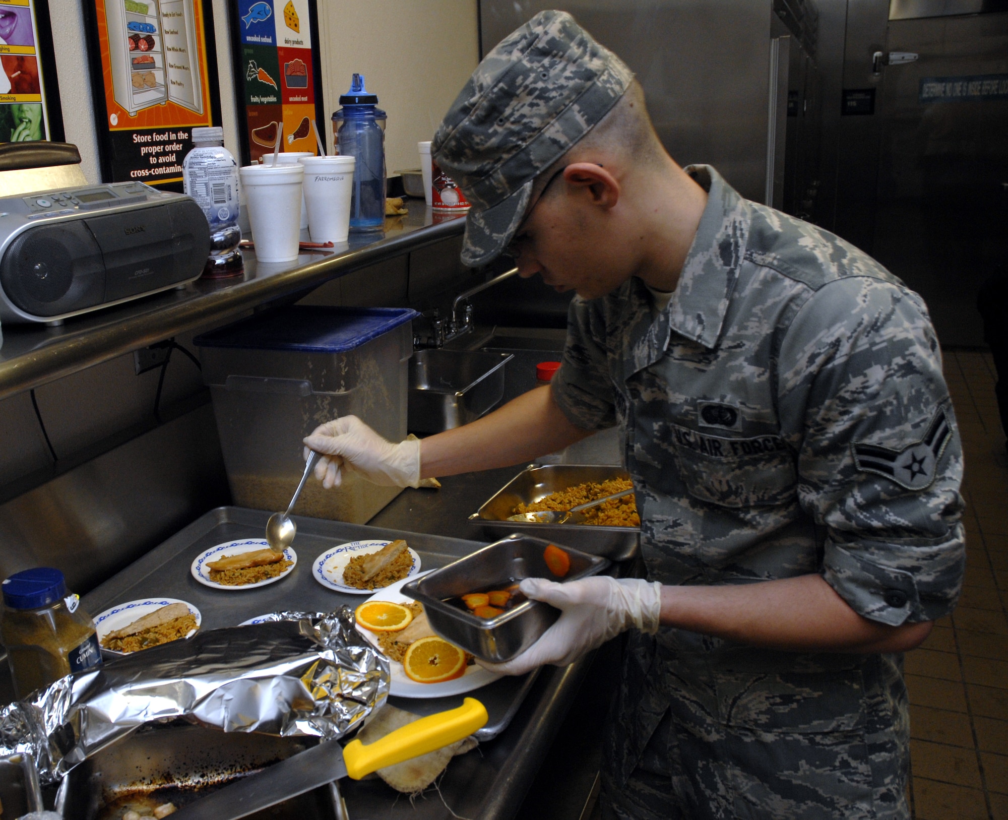 Airman 1st Class James Bloodworth, 1st Special Operations Force Support Squadron, adds a carrot and orange sauce to his entry, "Glazing Glory," during the chef of the quarter competition at the Riptide dining facility at Hurlburt Field April 13. A panel of four judges sampled the dishes and picked them based on their taste, presentation, creativity and originality. (DoD photo by U.S. Air Force Airman 1st Class Joe McFadden) (Released)