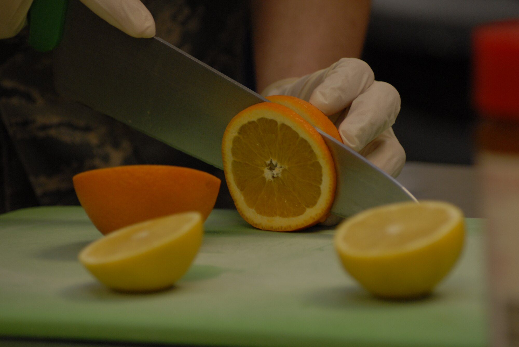 Senior Airman James Schneider, 1st Special Operations Force Support Squadron, slices an orange during the chef of the quarter competition at the Riptide dining facility at Hurlburt Field April 13. The orange was the secret ingredient that had to be used in this quarter's competition. (DoD photo by U.S. Air Force Airman 1st Class Joe McFadden) (Released)