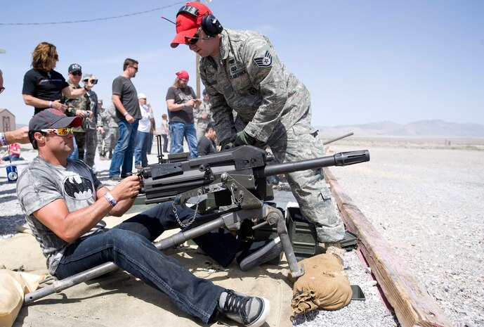 NEVADA TEST AND TRAINING RANGE --  Singer, Troy Gentry of the group "Montgomery Gentry" fires a Mk19, 40mm Automatic Grenade Launcher as Staff Sgt. Christopher McAlleer, 99th Ground Combat Training Squadron looks on.   Mr. Gentry and other country music stars toured the ground combat training facility before the Academy of Country Music's USO concert at Nellis Air Force Base April 17, 2010. (U.S. Air Force photo by Lawrence Crespo)
