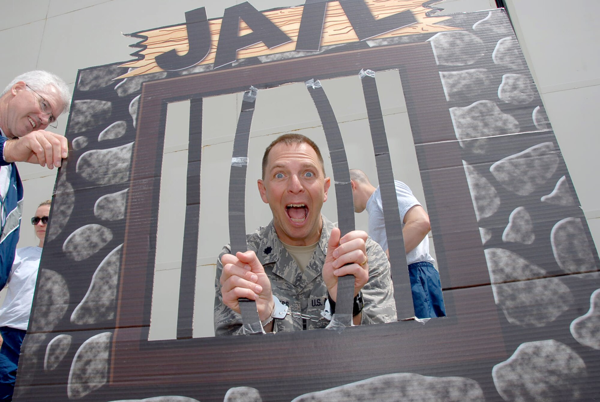 Chaplain (Lt. Col.) Steve Rogers, 189th Airlift Wing, participates in the "Jail and Bail" event during the wing's annual family day. Tech. Sgt. Alan Terrell, 189th Airlift Wing chaplain's assistant, "assists" the chaplain in his hour of need. (U.S. Air Force photo by Master Sgt. Dianna Seerey)