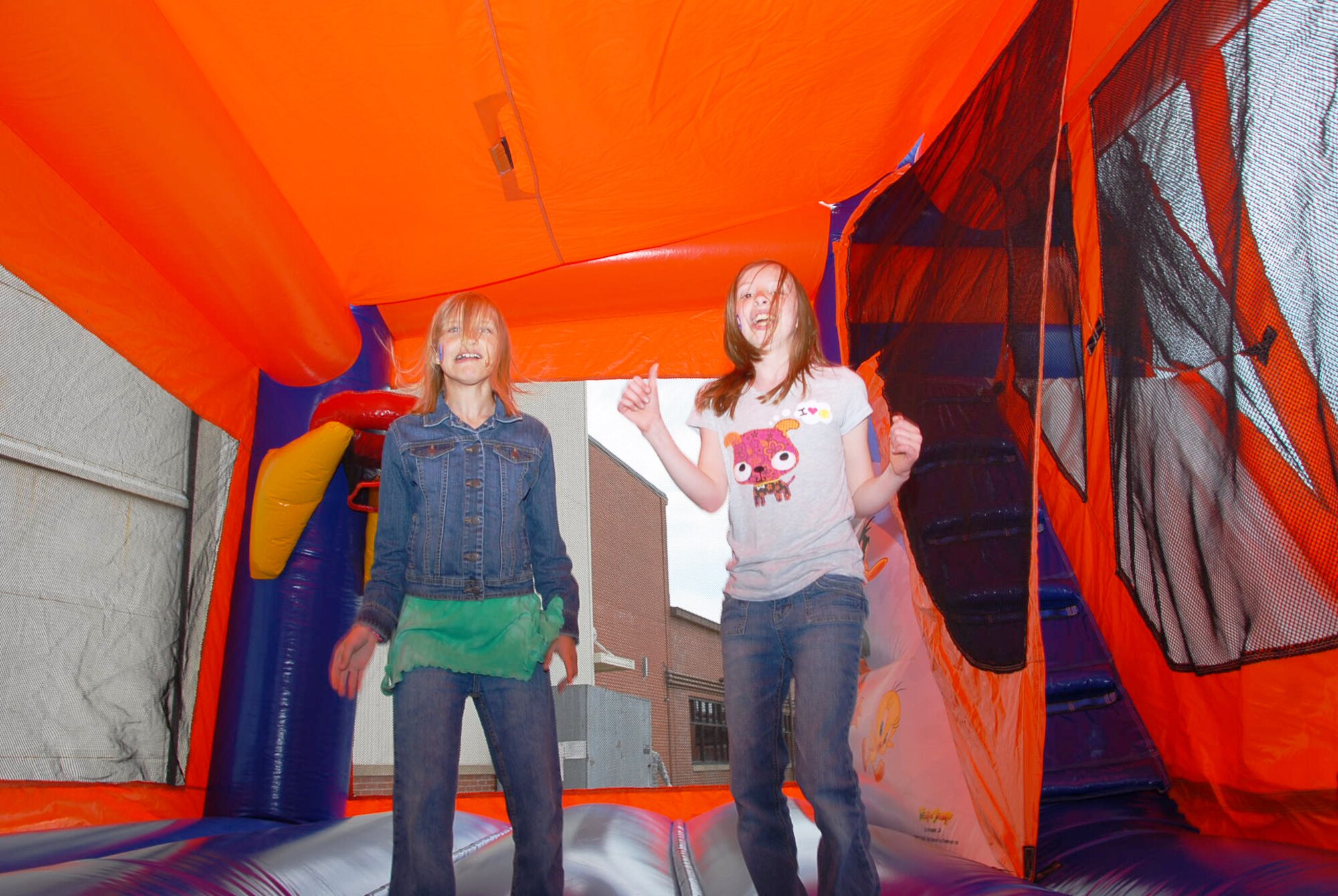 Hannah Stewart, daughter of Tech. Sgt. Scott Stewart, a 189th Aircraft Maintenance Squadron crew chief, and her friend, Abigail Chynoweth, bounce in an air-filled playhouse during the 189th Airlift Wing’s Family Day. (U.S. Air Force photo by Master Sgt. Dianna Seerey)